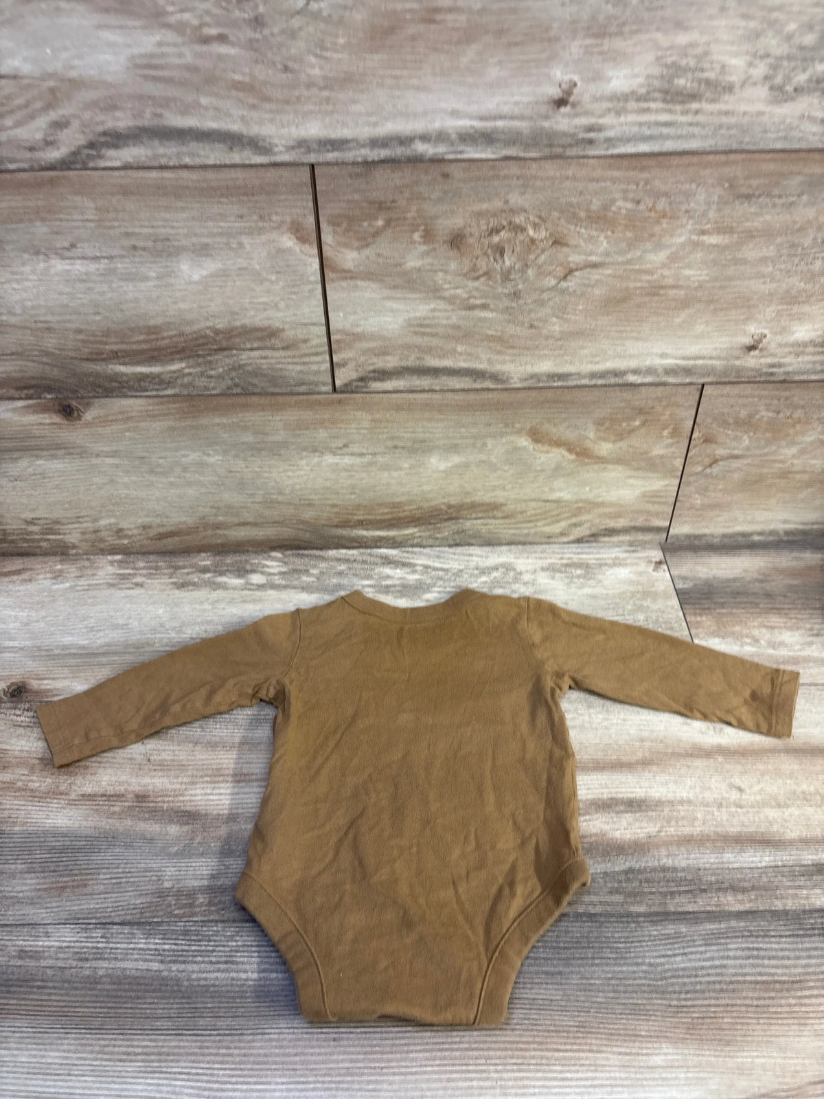 Back view of a brown Baby Gap long sleeve bodysuit for infants, laid on a rustic wood background.
