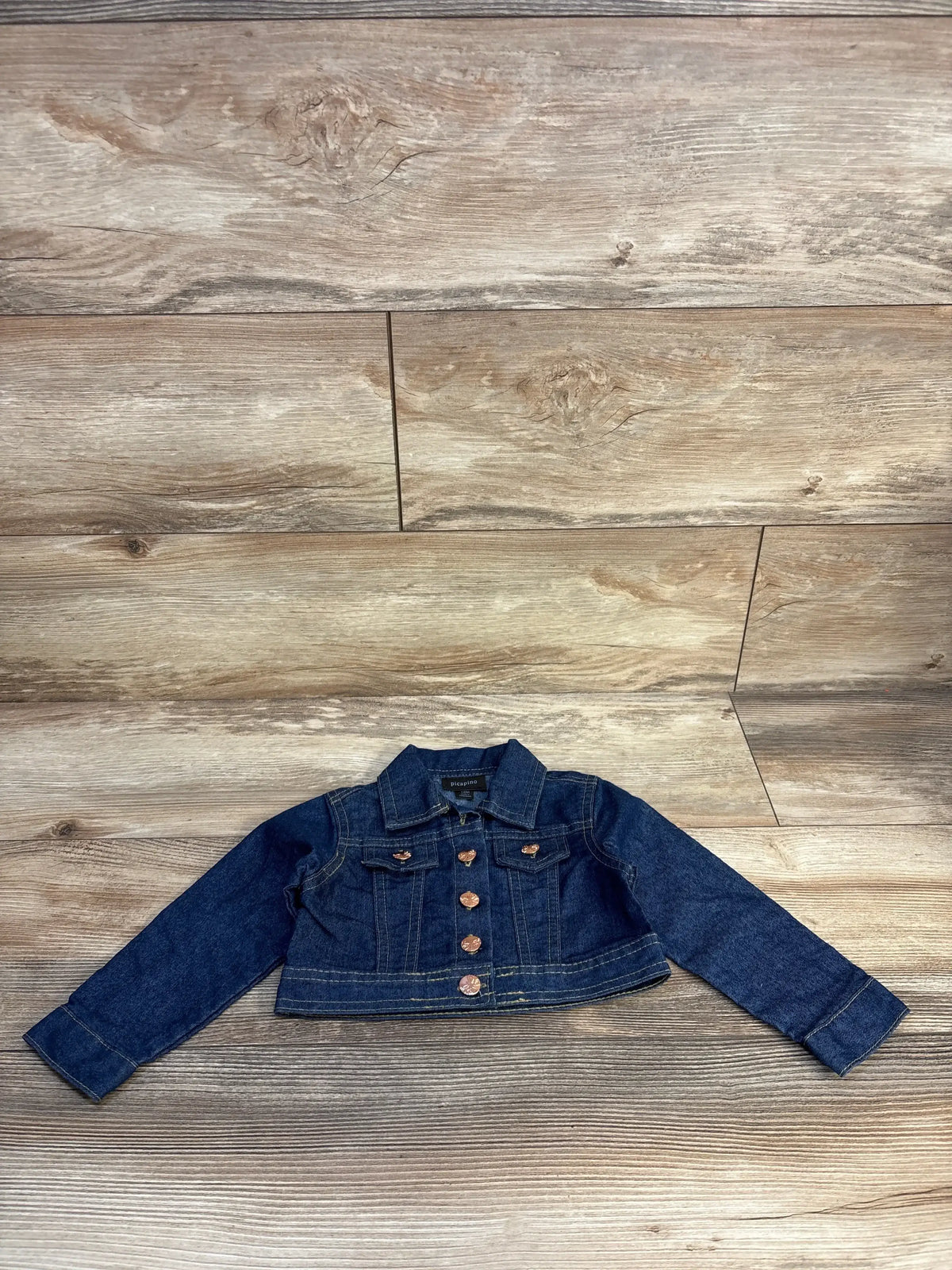 Toddler denim jacket with copper buttons on wood background, gently used kids clothing