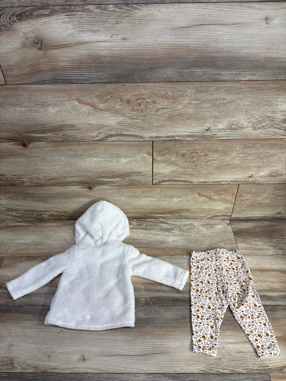 white hooded fleece jacket and floral pattern leggings on wood floor