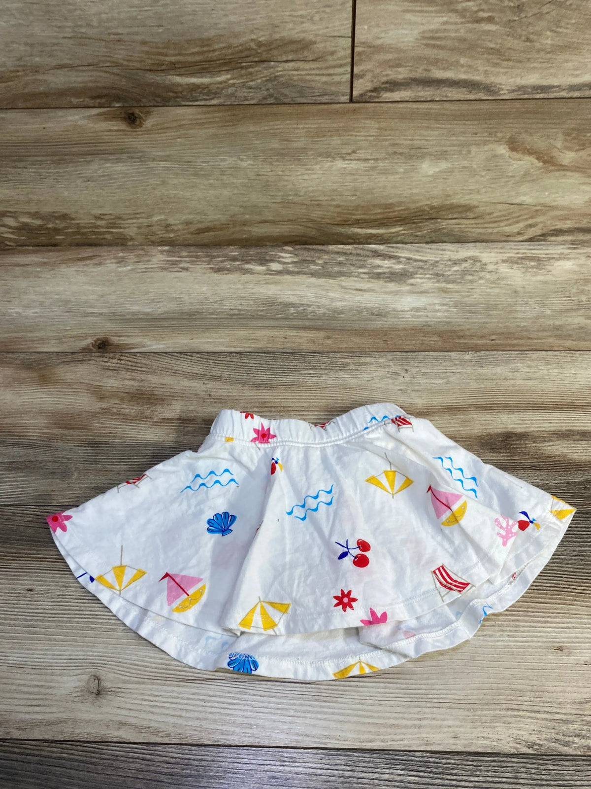 White Baby Gap pull-on skort with colorful beach print featuring umbrellas and shells