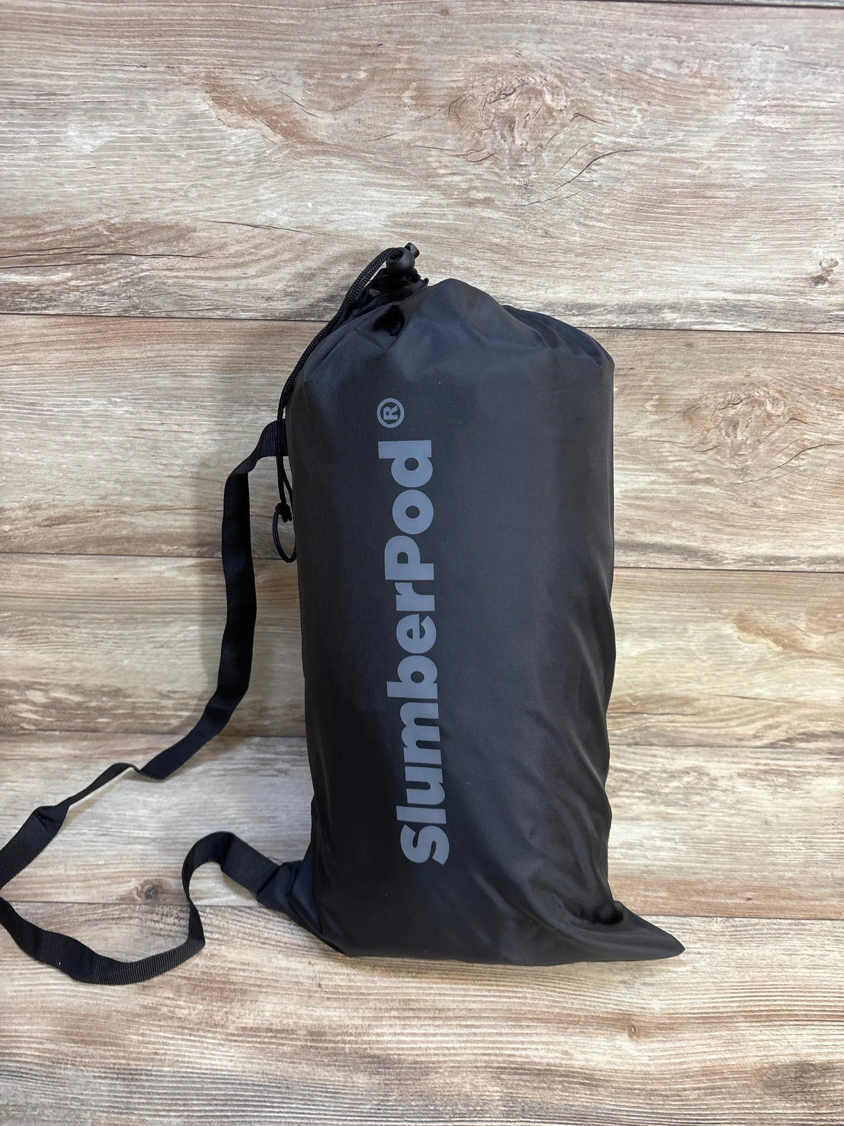 SlumberPod portable baby sleep environment bag on wood floor