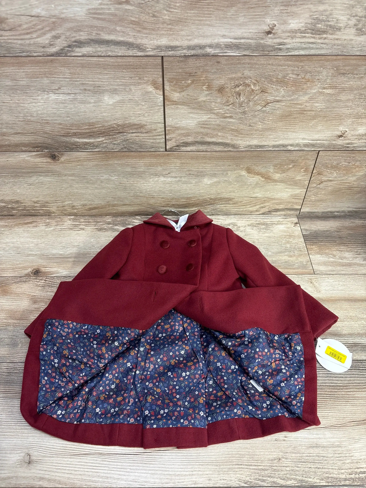 Burgundy double-breasted toddler coat with floral lining on wooden floor