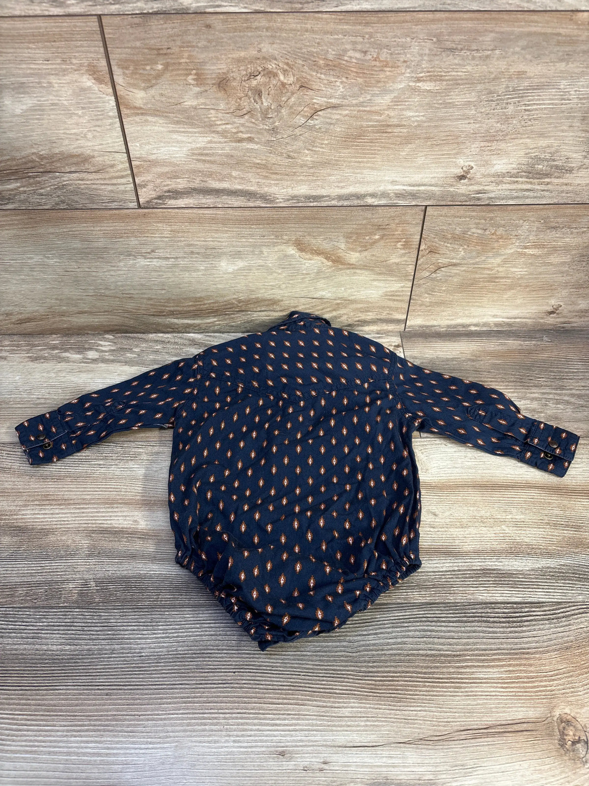 Back view of Cody James navy polo bodysuit showcasing long sleeves and tan diamond pattern on wood floor