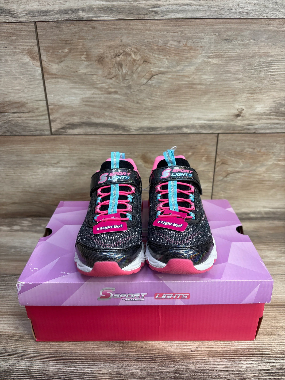 Kids Skechers Sport Lights light-up sneakers in pink and black on a pink and purple shoebox