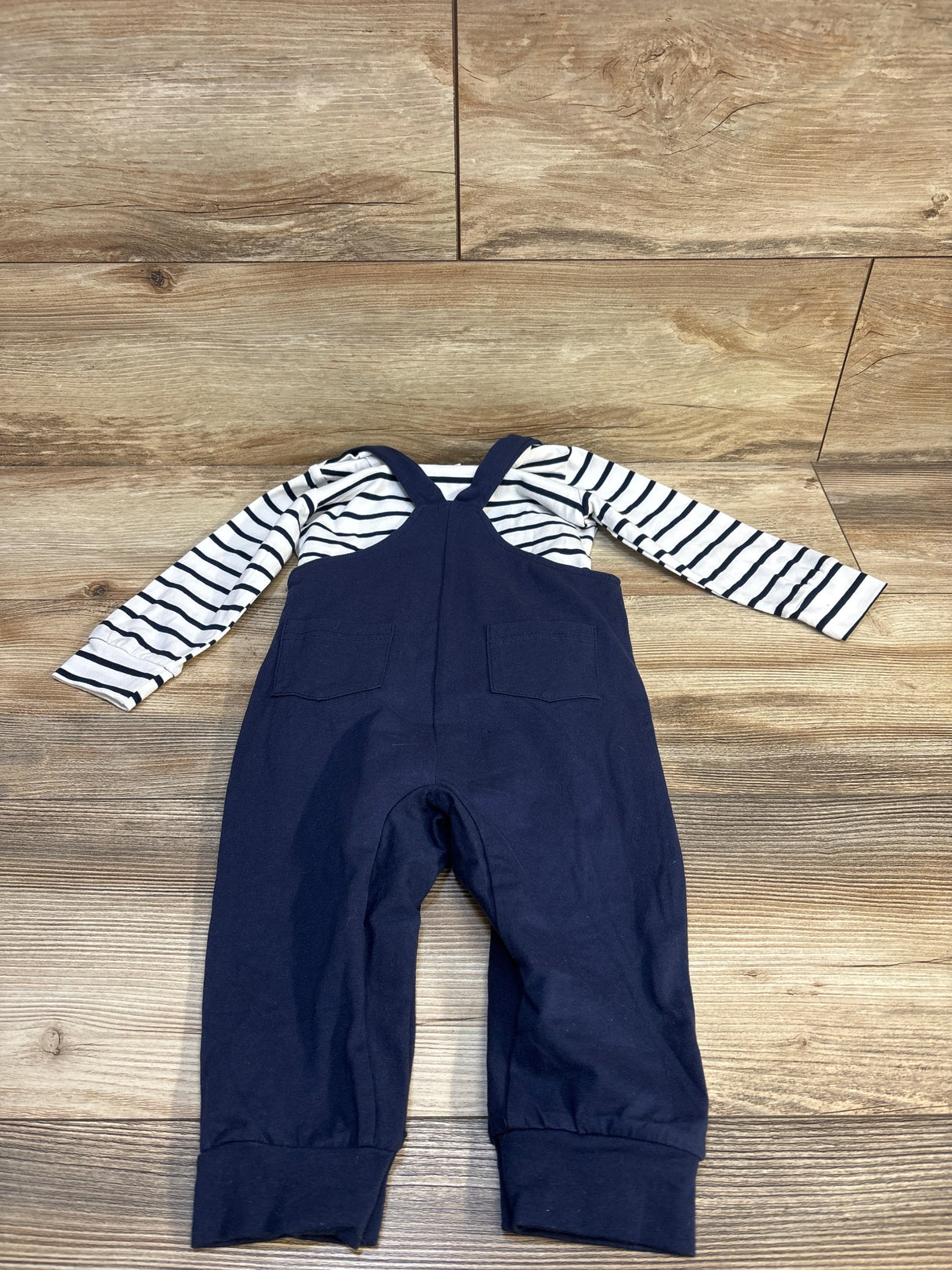 Navy overalls with striped long-sleeve shirt, kids clothing set on wood floor