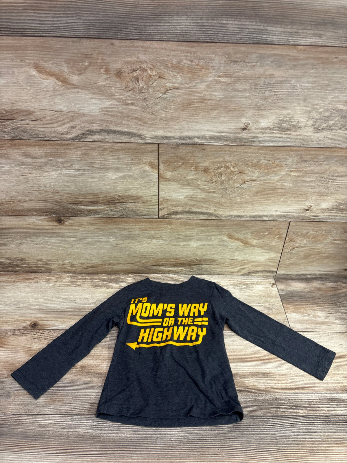 Front view of Children’s Place grey 2T long sleeve shirt with yellow It’s Mom’s Way Or The Highway graphic on wood