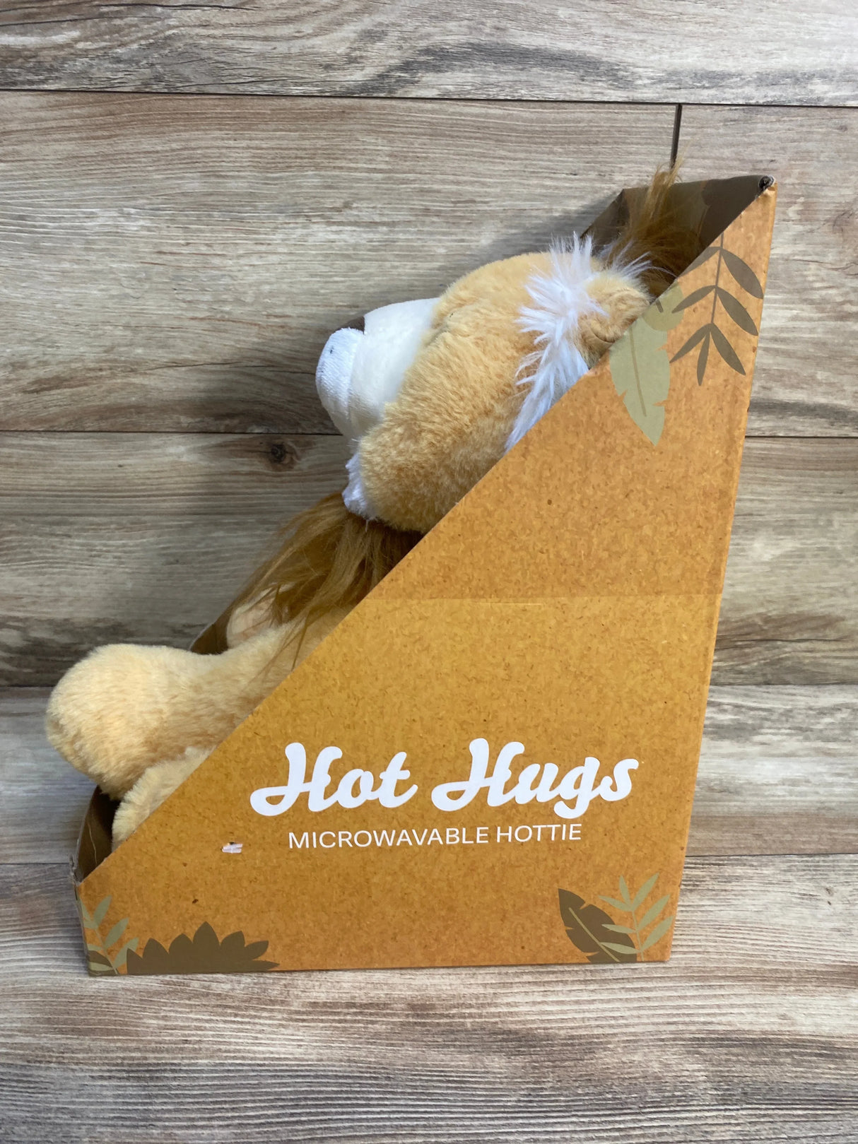Plush lion microwavable hottie in brown Hot Hugs box on wooden background