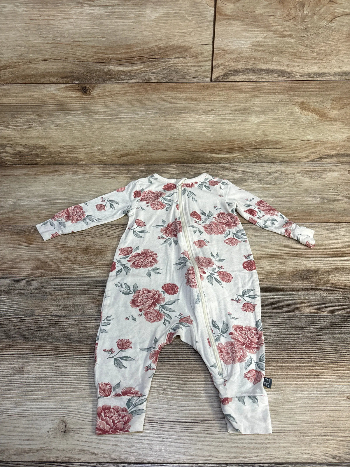 Front view of Modern Moments floral footless sleeper in ivory with floral print and front zipper on wood grain background