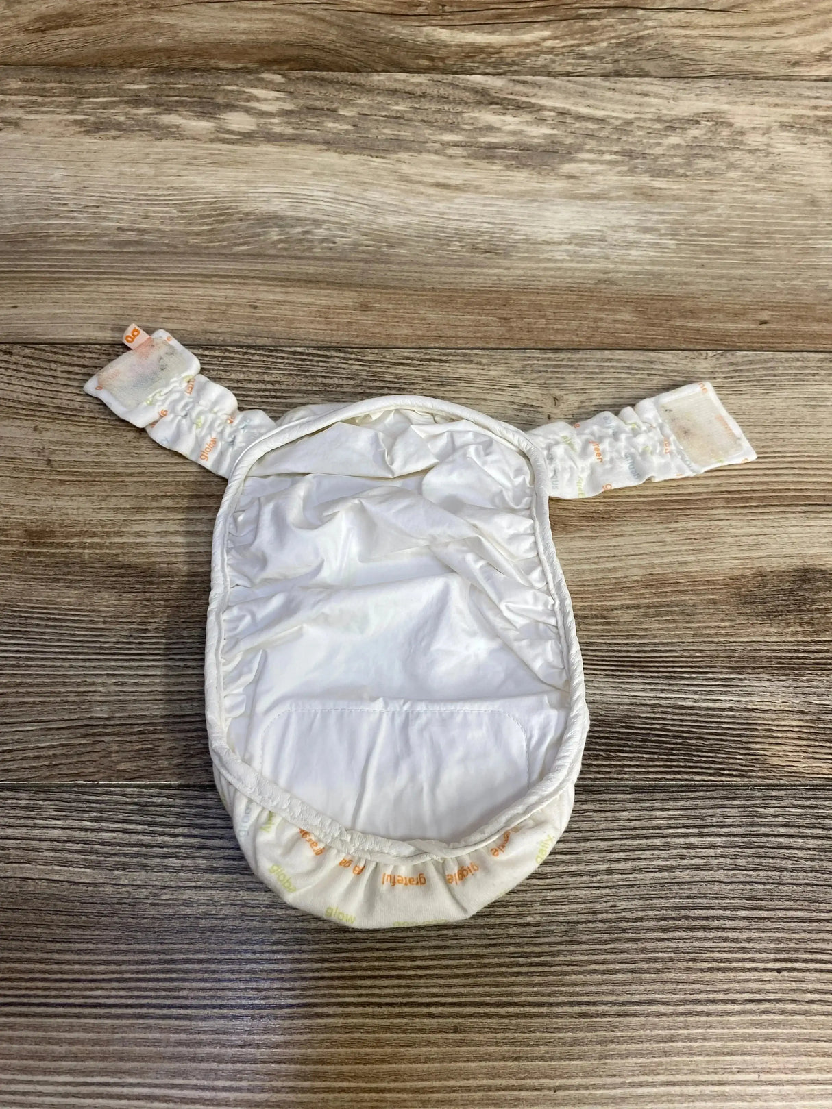 Front view of gDiapers newborn cloth diapers 8-pack showing ivory color and word print on white background