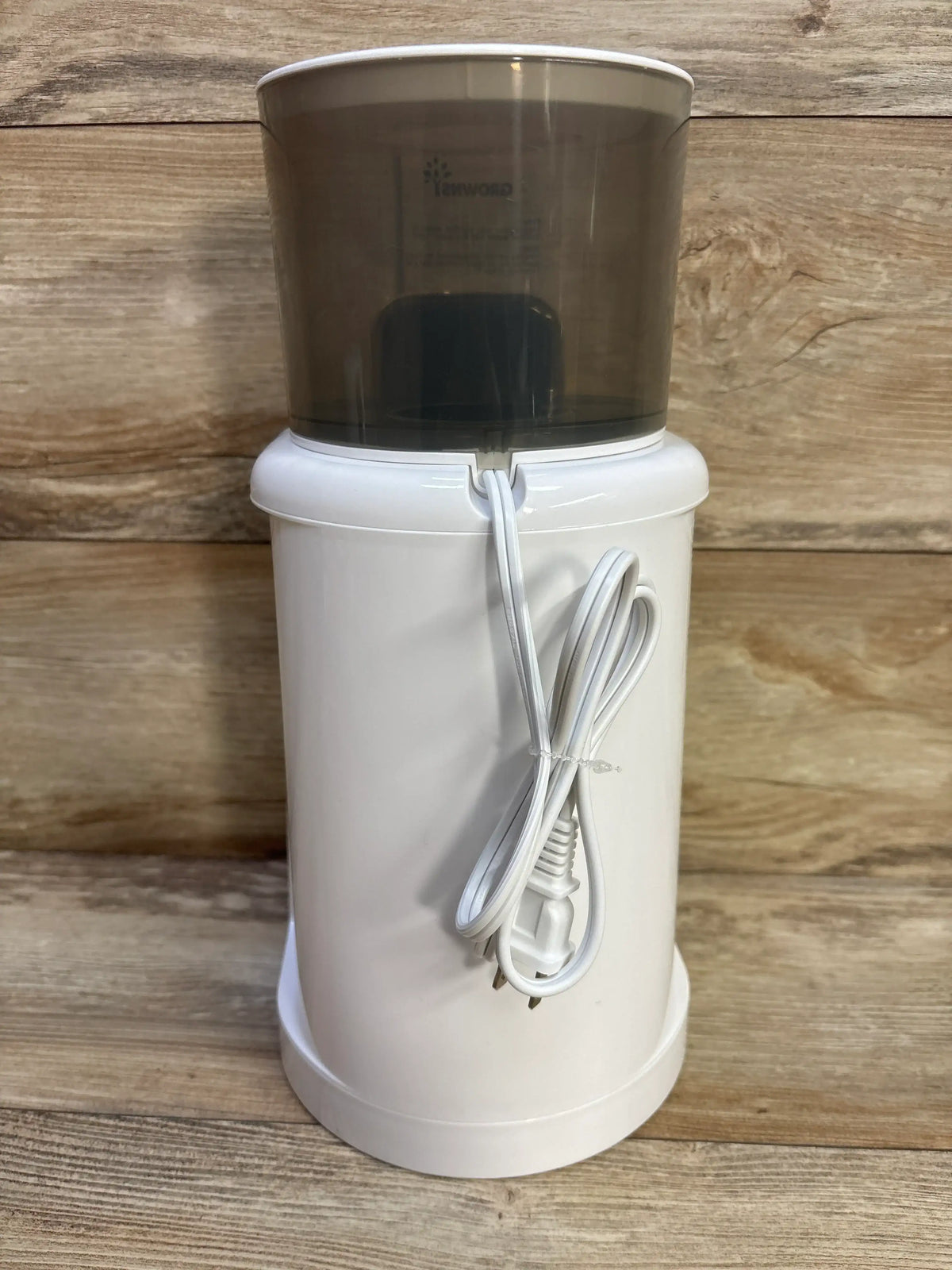 Front view of GROWNSY Instant Baby Bottle Warmer showing white base, translucent reservoir, and coiled power cord on wood