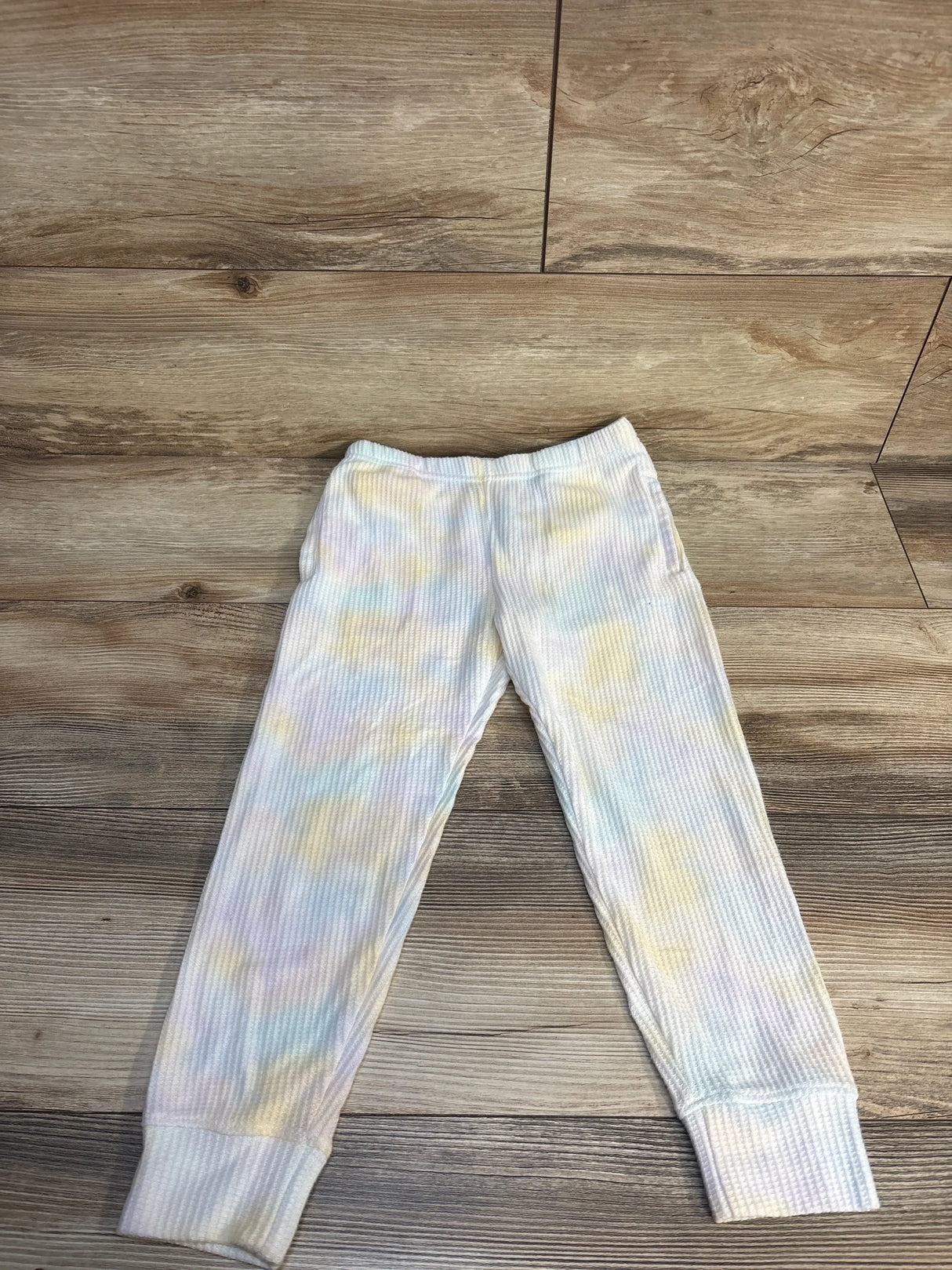 Pastel tie-dye ribbed kids jogger pants on wood background, children's clothing