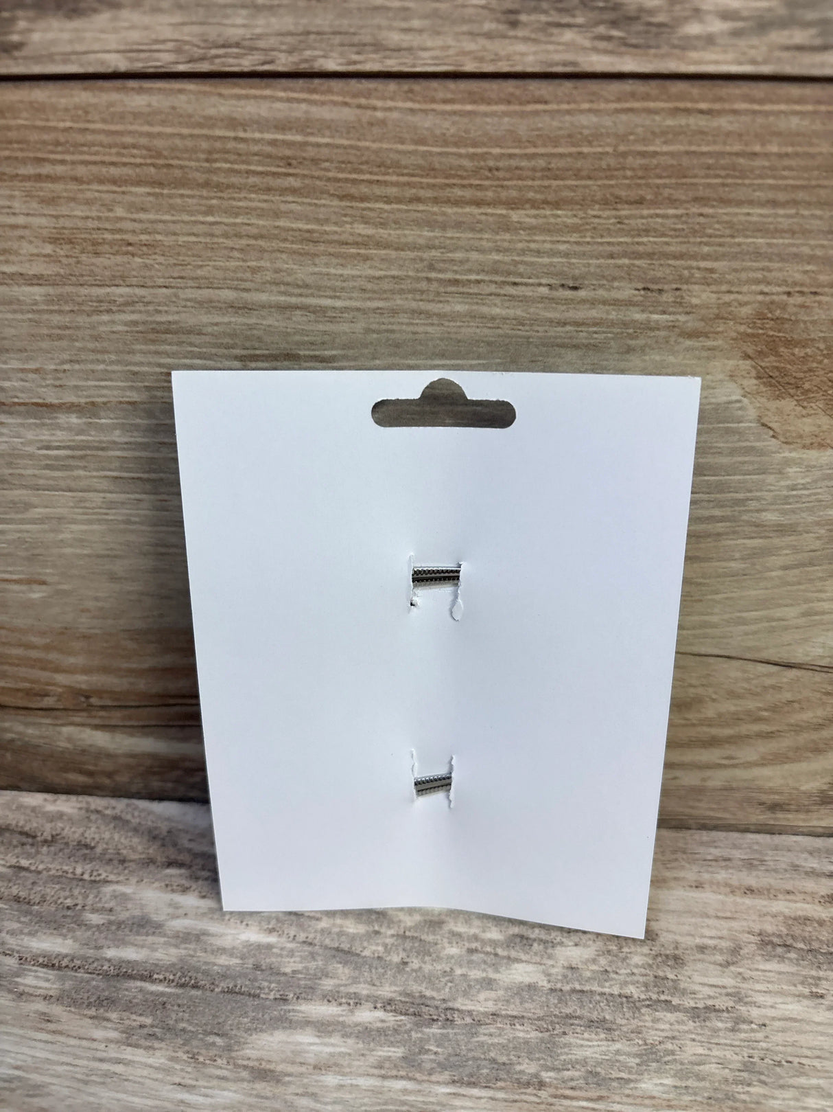 Front view of hair bows display card showing two attachment slots where the 2-pack bows were, on a wood background
