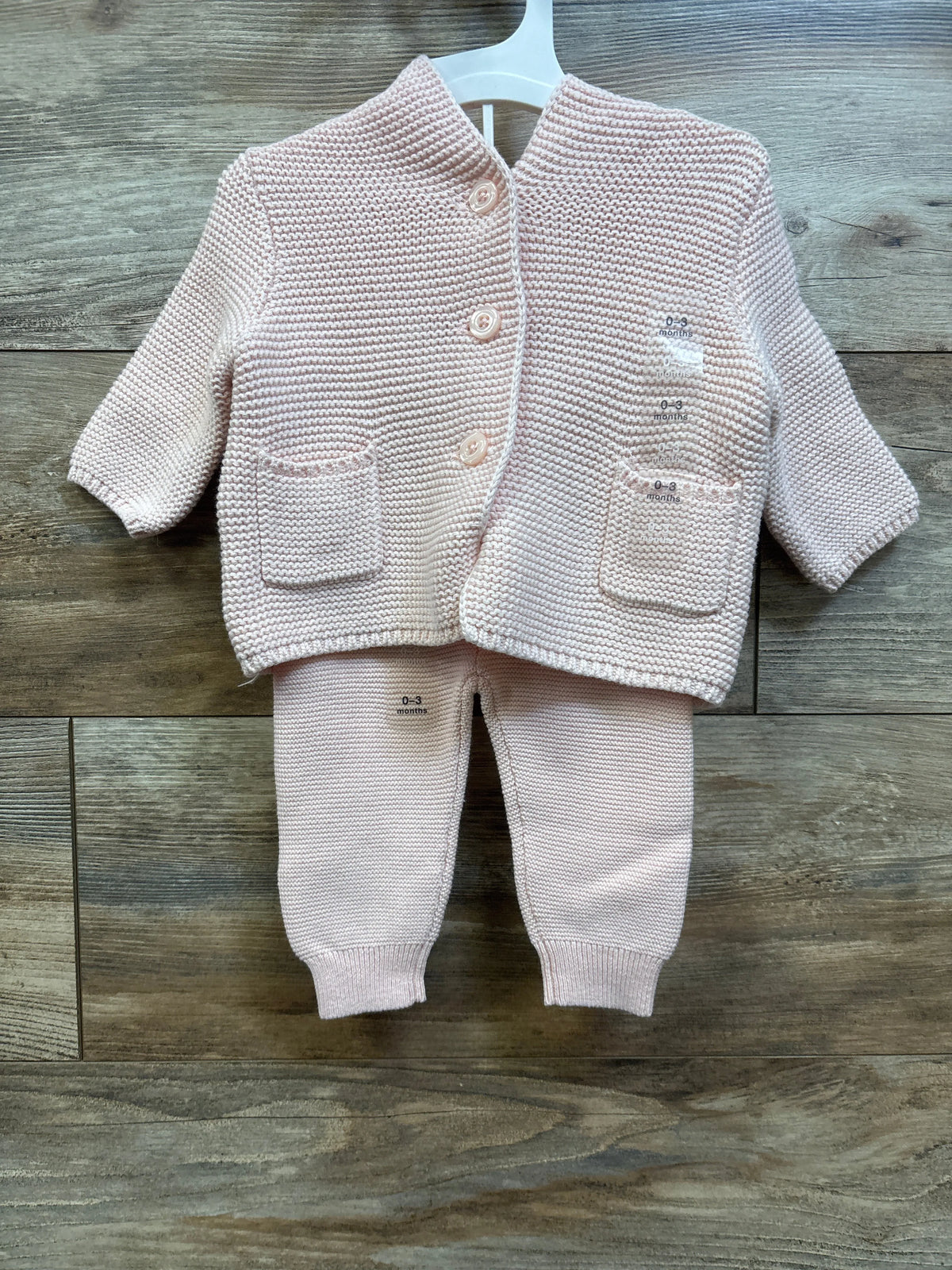 Flat lay of Baby Gap pink 0-3m sweater set with button-front cardigan, pockets, and matching pants on wood