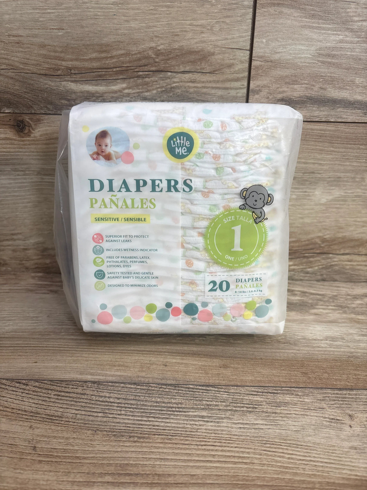 Front view of Little Me size 1 diaper pack showcasing Sensitive label, size 1 badge and 20 count on wood floor background