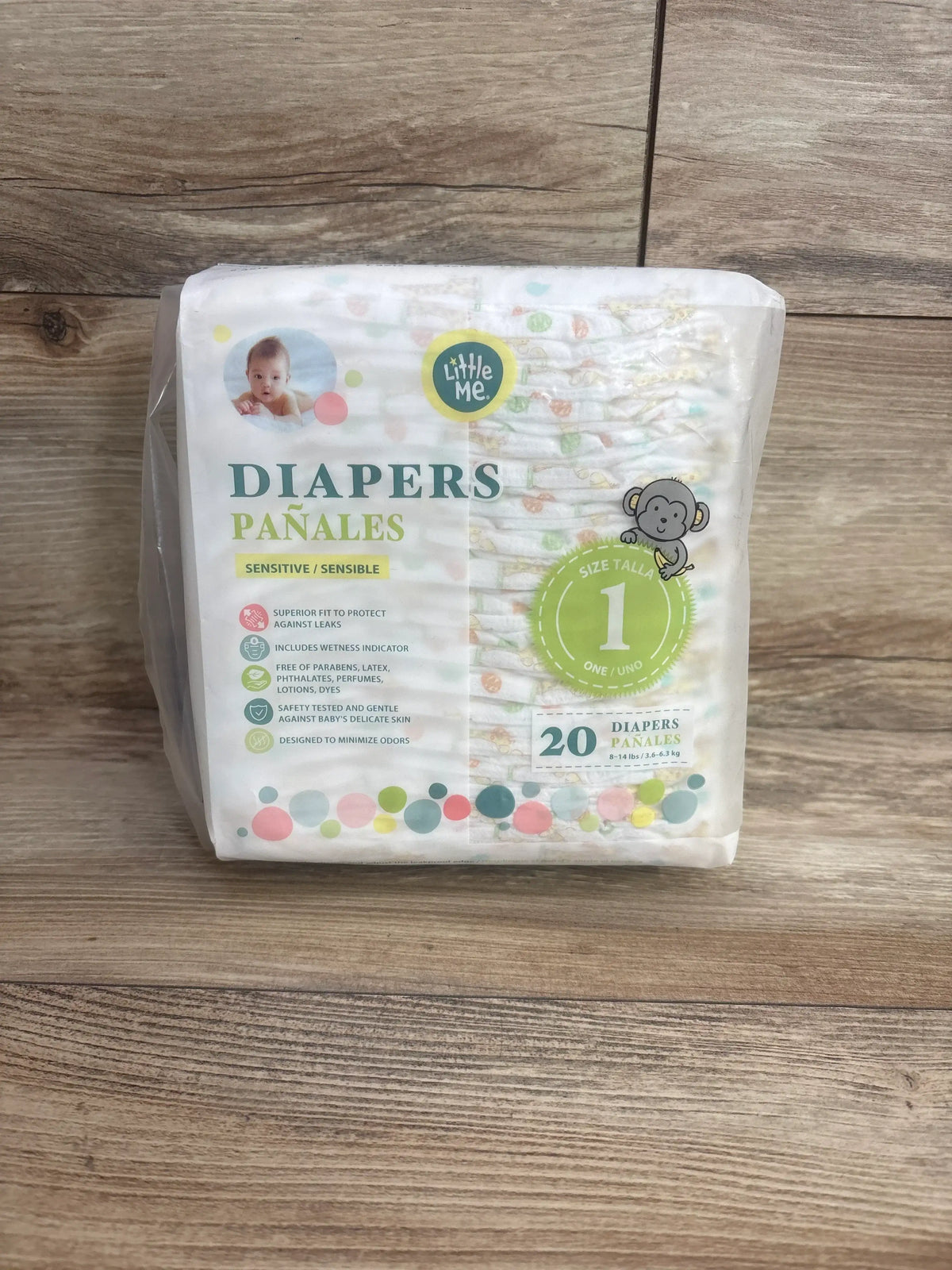 Front view of Little Me size 1 diaper pack showcasing Sensitive label, size 1 badge and 20 count on wood floor background