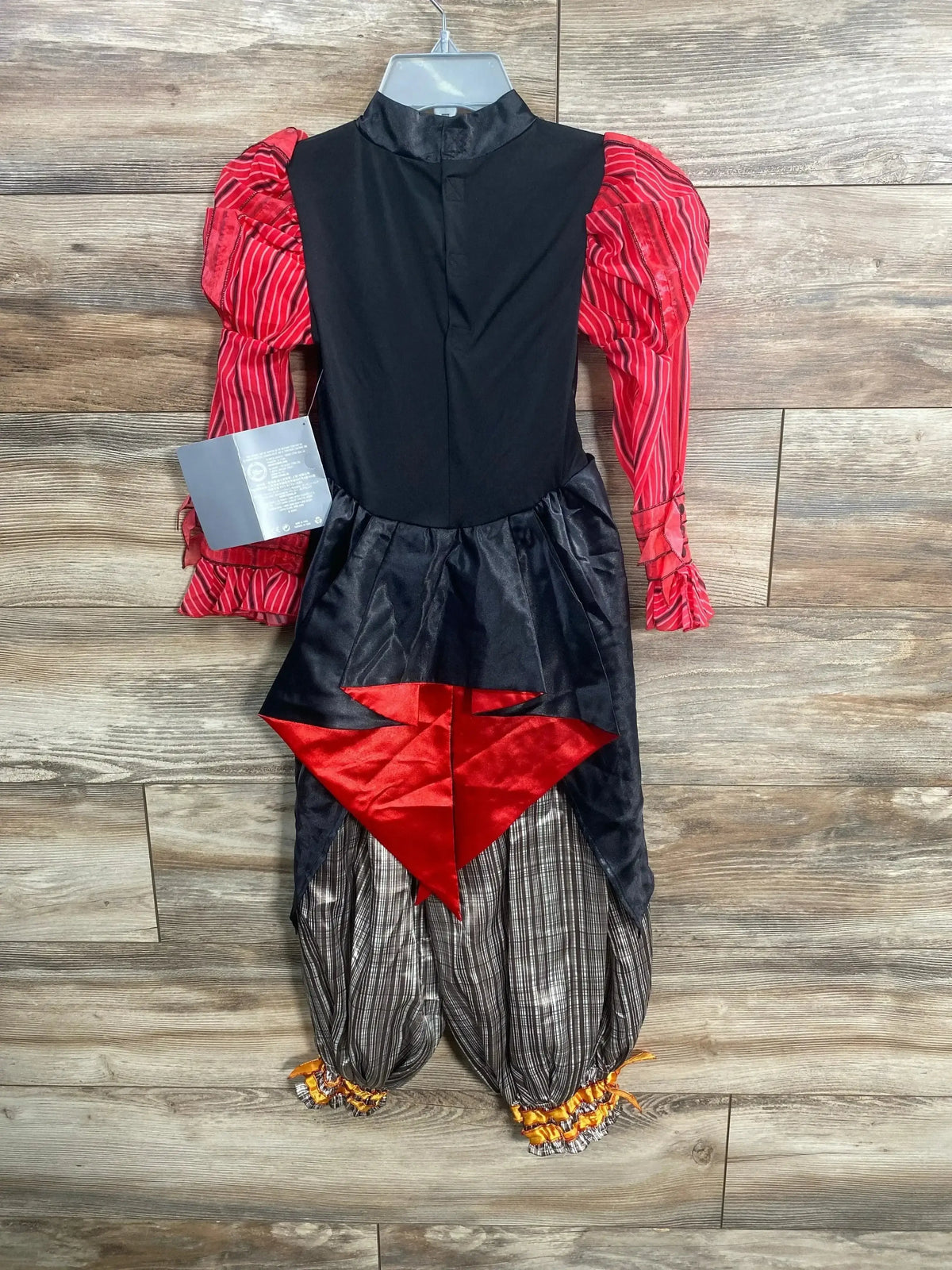 Front view of children’s Alice Through the Looking Glass costume with black bodice, red striped puff sleeves and red satin front diamond on wood floor