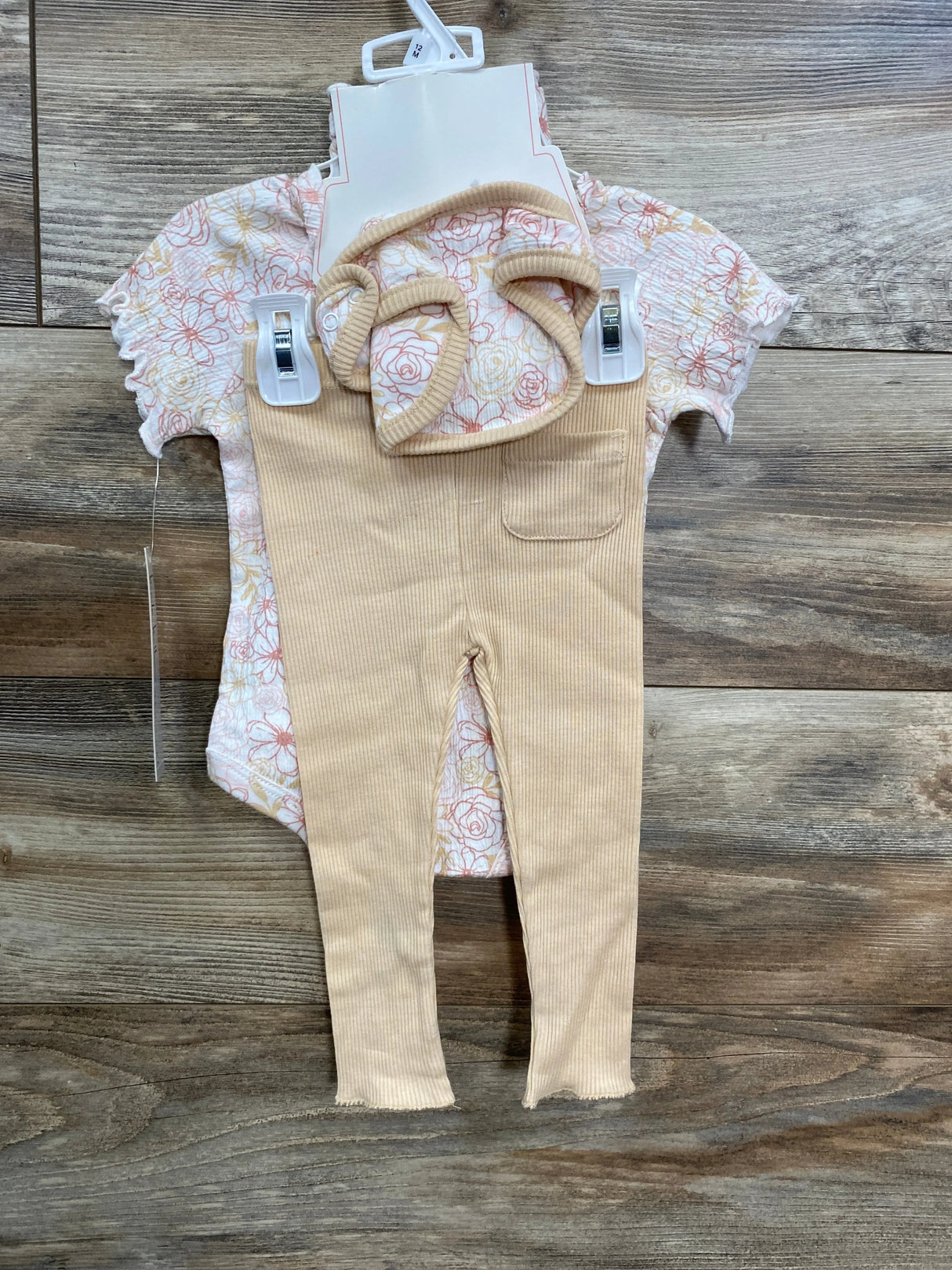 Front flat lay of Nicole Miller 4-piece floral bodysuit and beige ribbed leggings set with matching headband on wooden floor