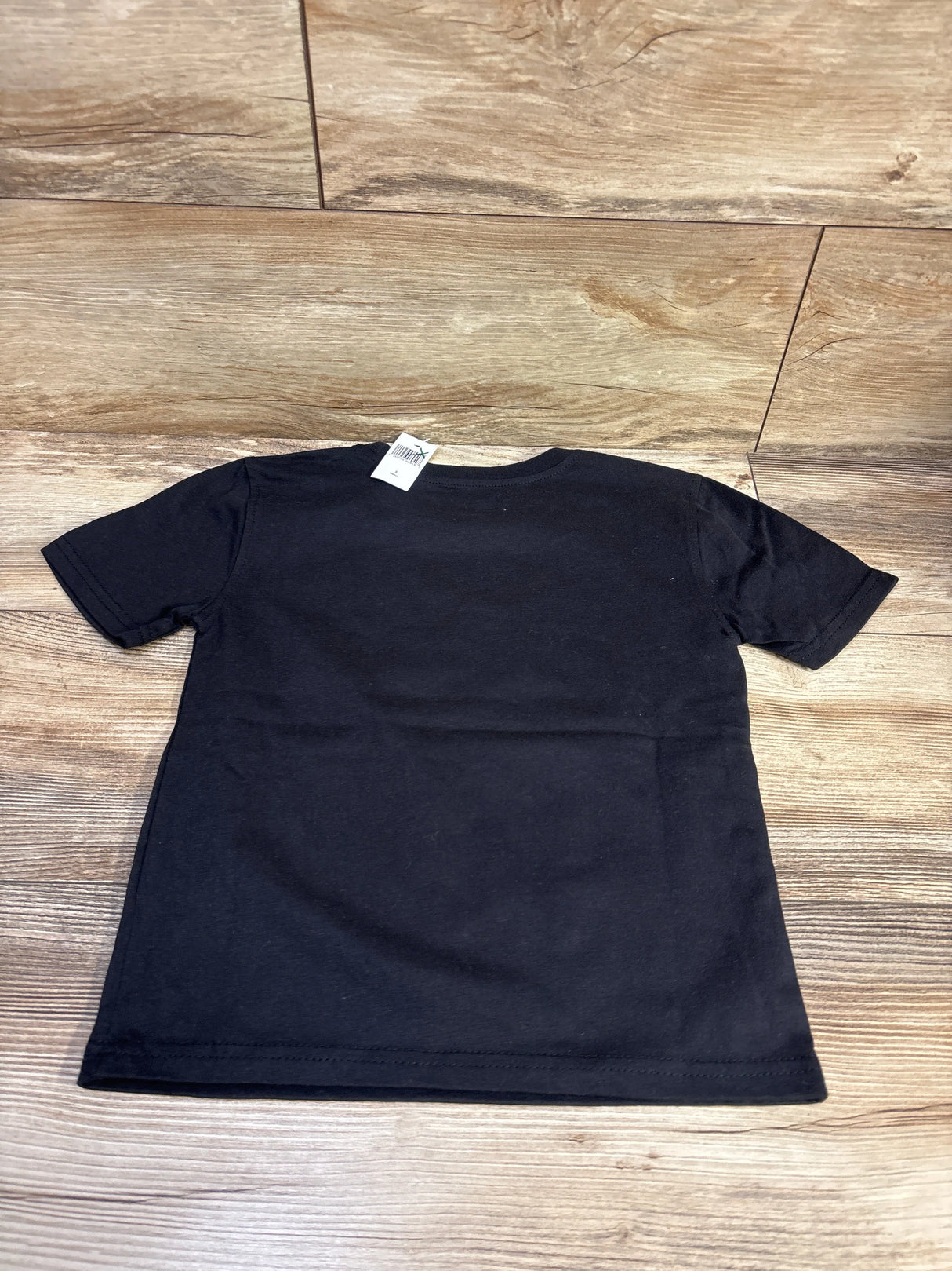 Back view of Disney Store Star Wars black shirt in toddler size 5/6T with short sleeves on a wood floor