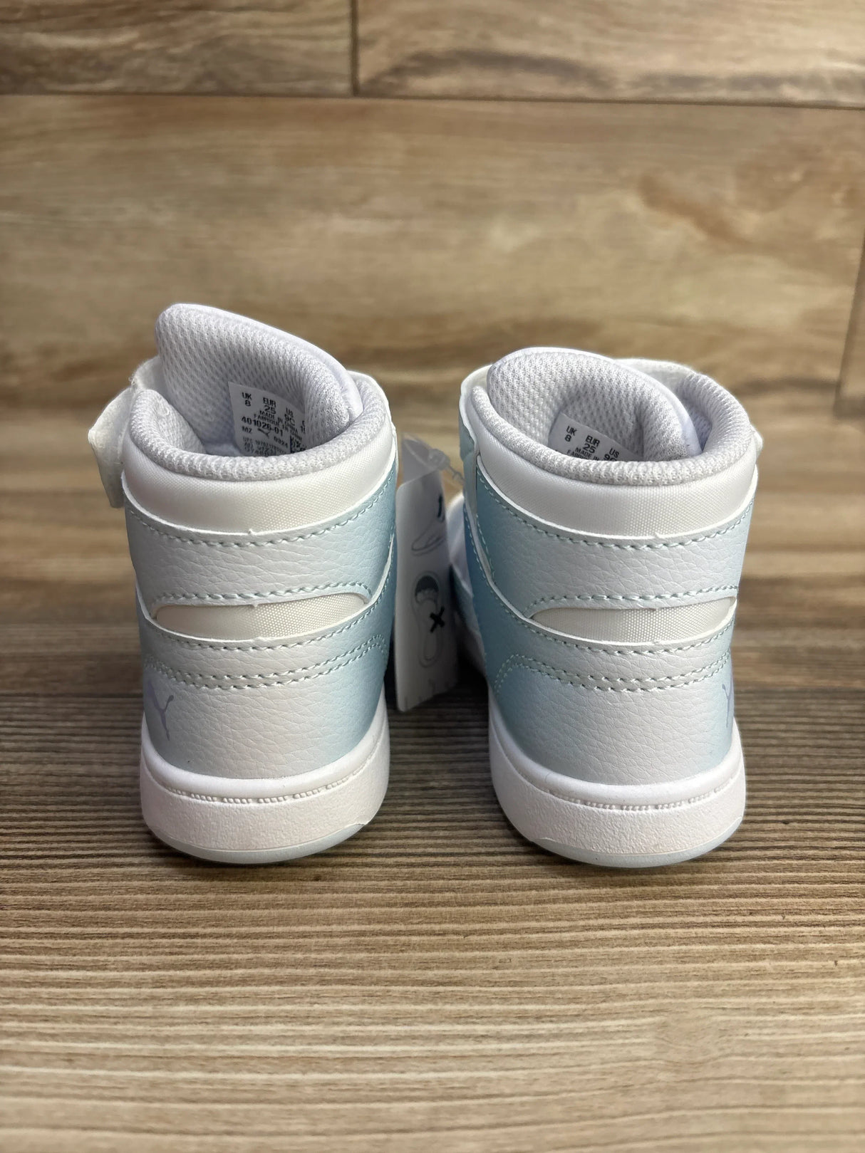 Rear view of Puma Rebound Layup Euphoria V toddler sneakers size 9C showing light blue to white leather gradient and padded ankle collar on wood surface