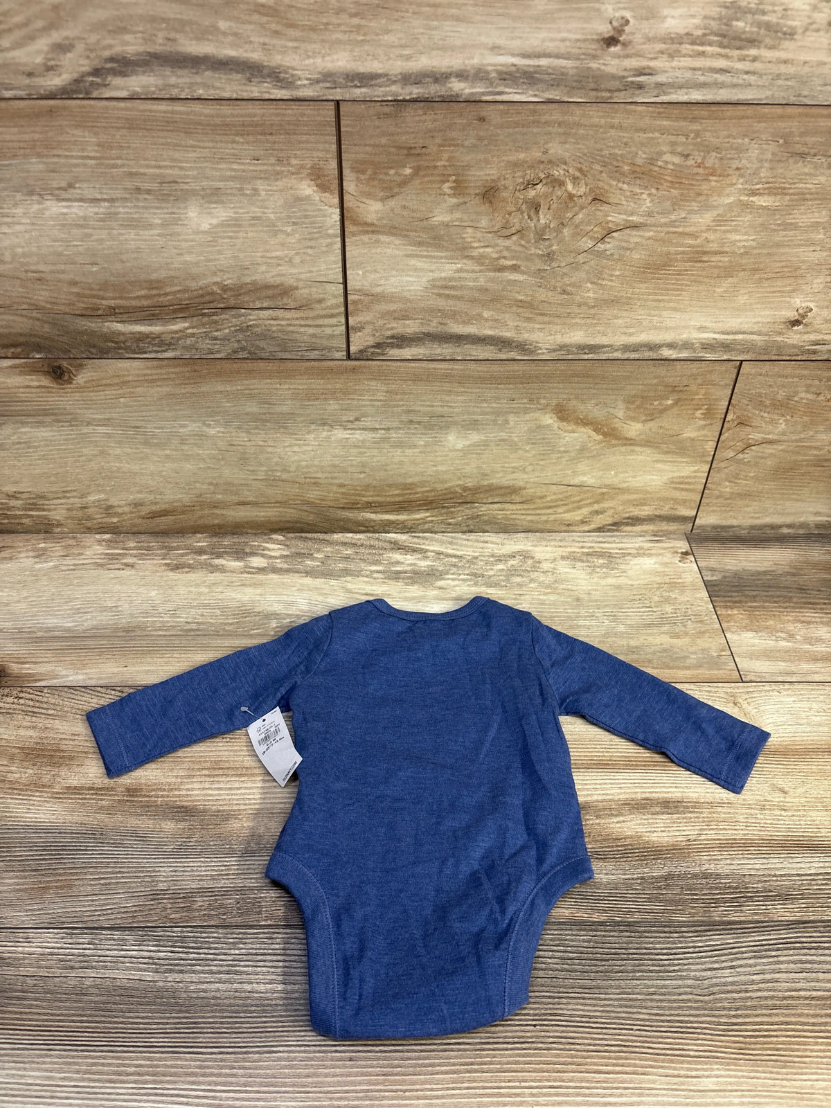 Back view of Old Navy baby bodysuit showing long sleeves and blue heather fabric on wood plank background