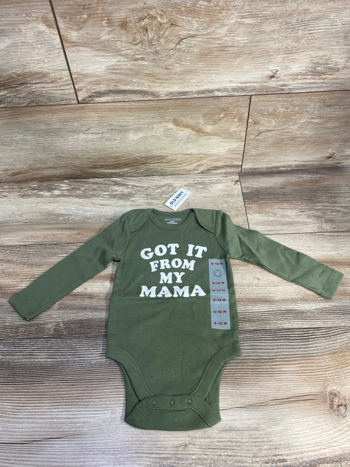Olive green baby bodysuit with 'Got It From My Mama' text on wood background