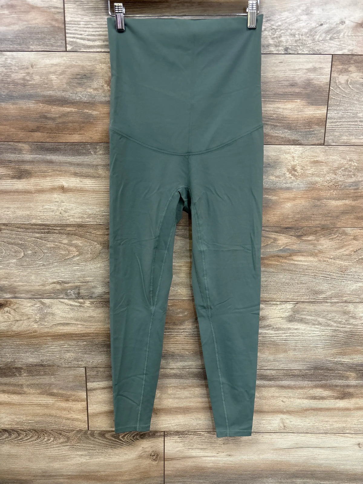 Front view of Poshdivah full-panel maternity leggings in olive showcasing high waistband and seam details on wood background