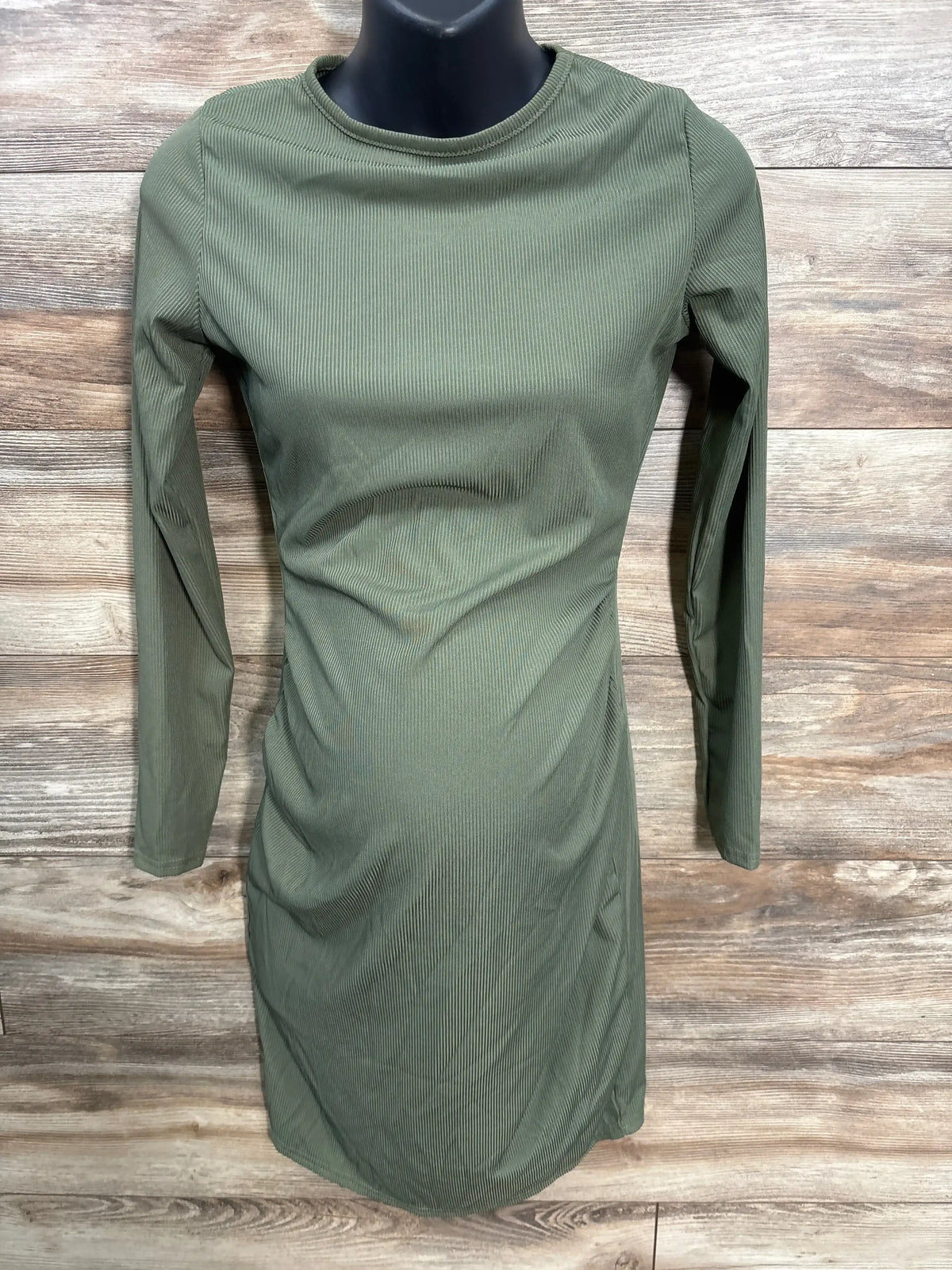 Olive green ribbed long sleeve maternity dress on mannequin, wood background