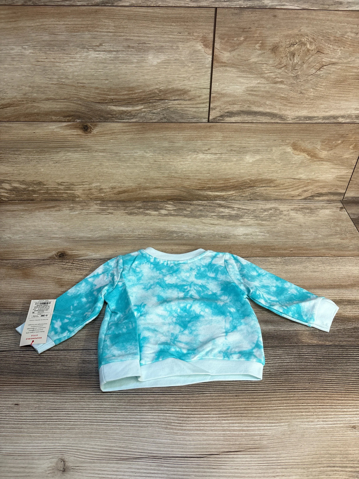 Blue and white tie dye long sleeve toddler sweatshirt on wood background