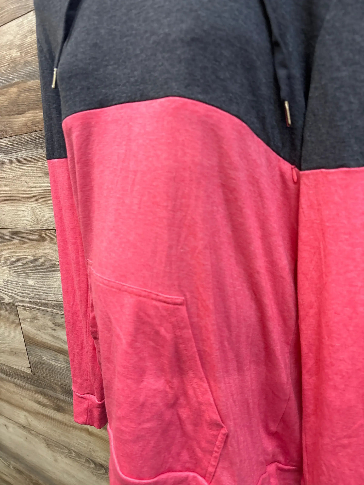 Close-up of Bearsland maternity pullover sweatshirt showcasing charcoal gray and pink color blocking with a kangaroo pocket