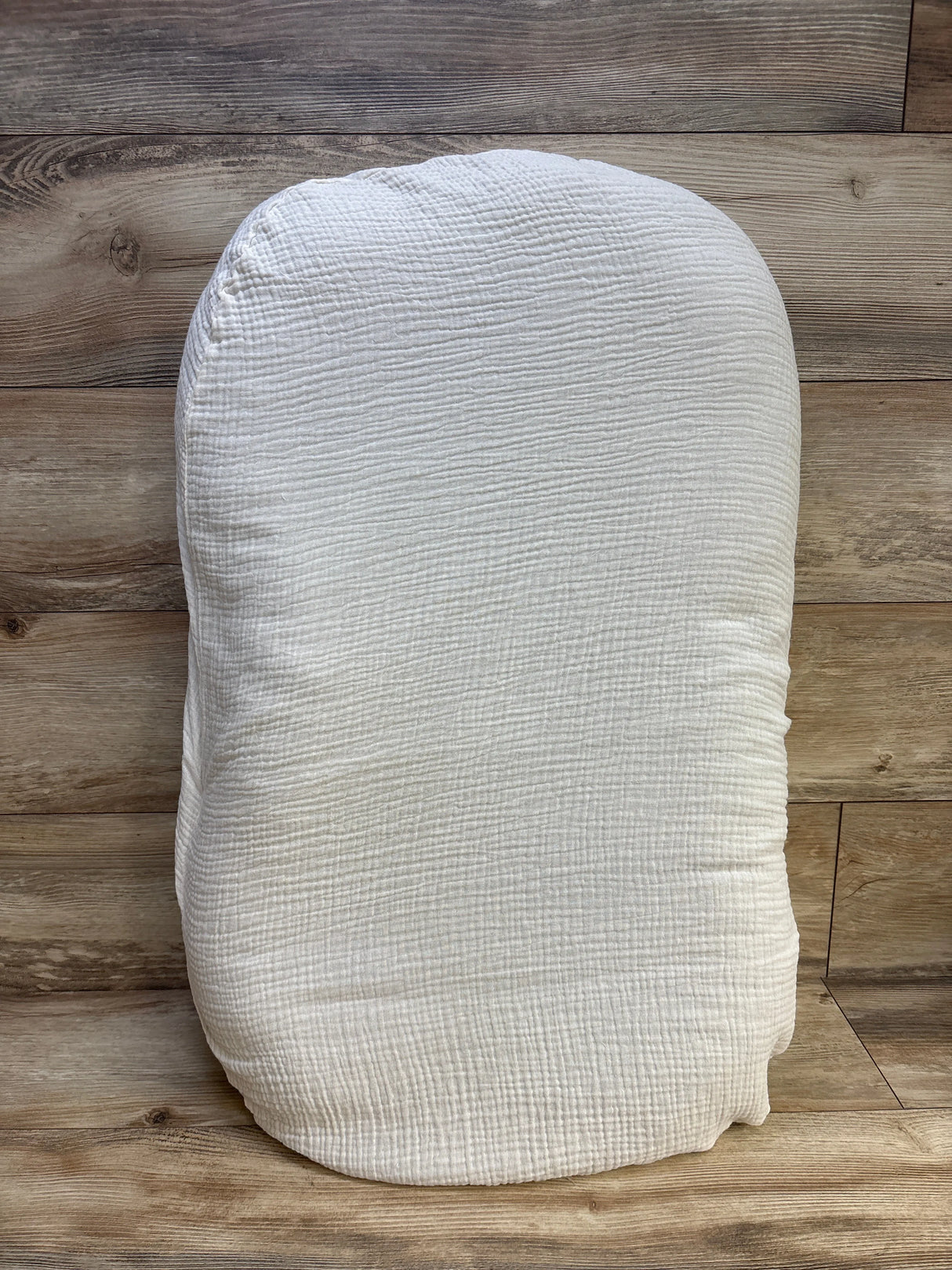 White textured organic cotton pillow on wooden floor background