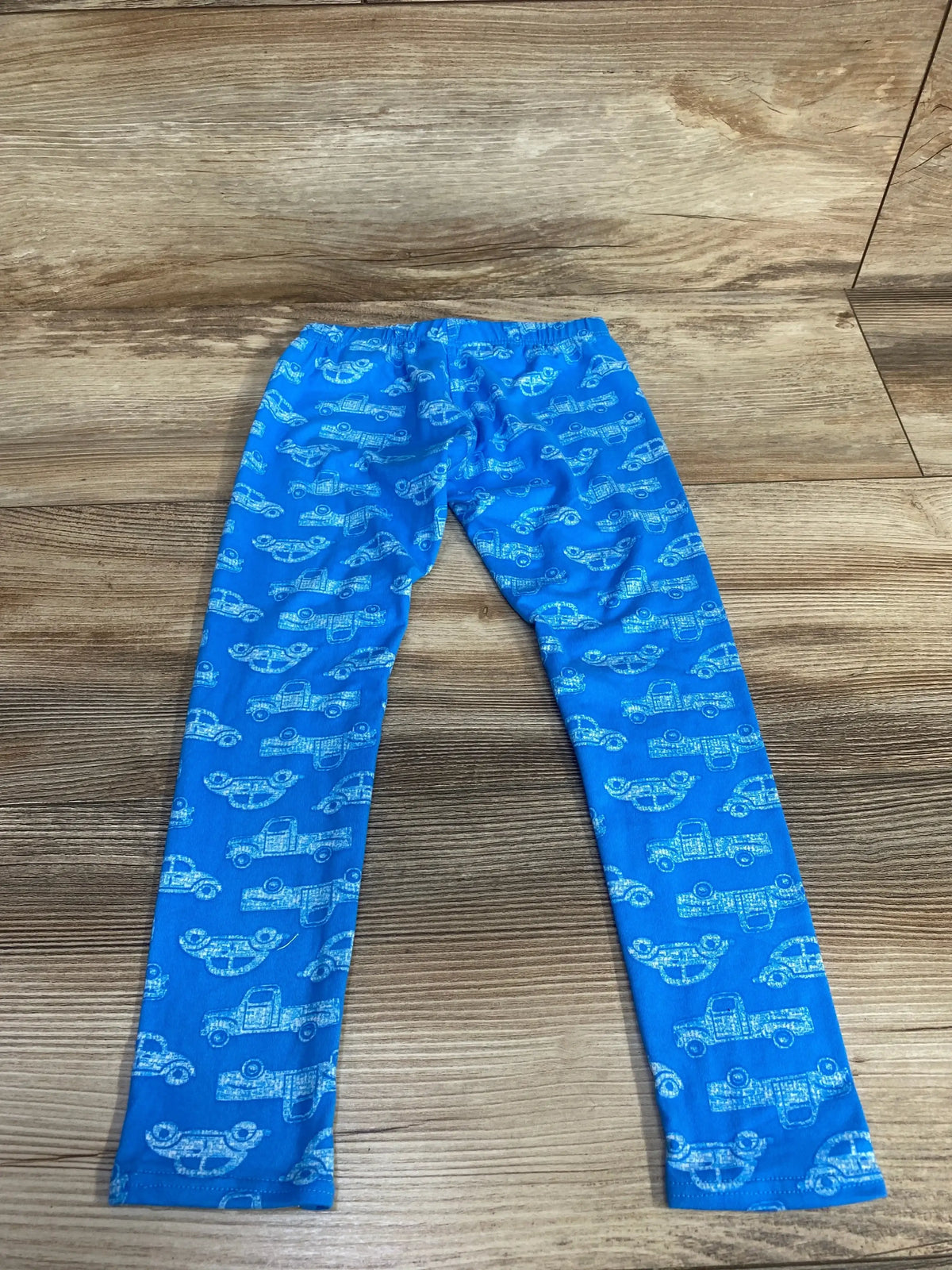 Front view of blue toddler leggings showcasing smiley dot and car print, size 3-4T on white background