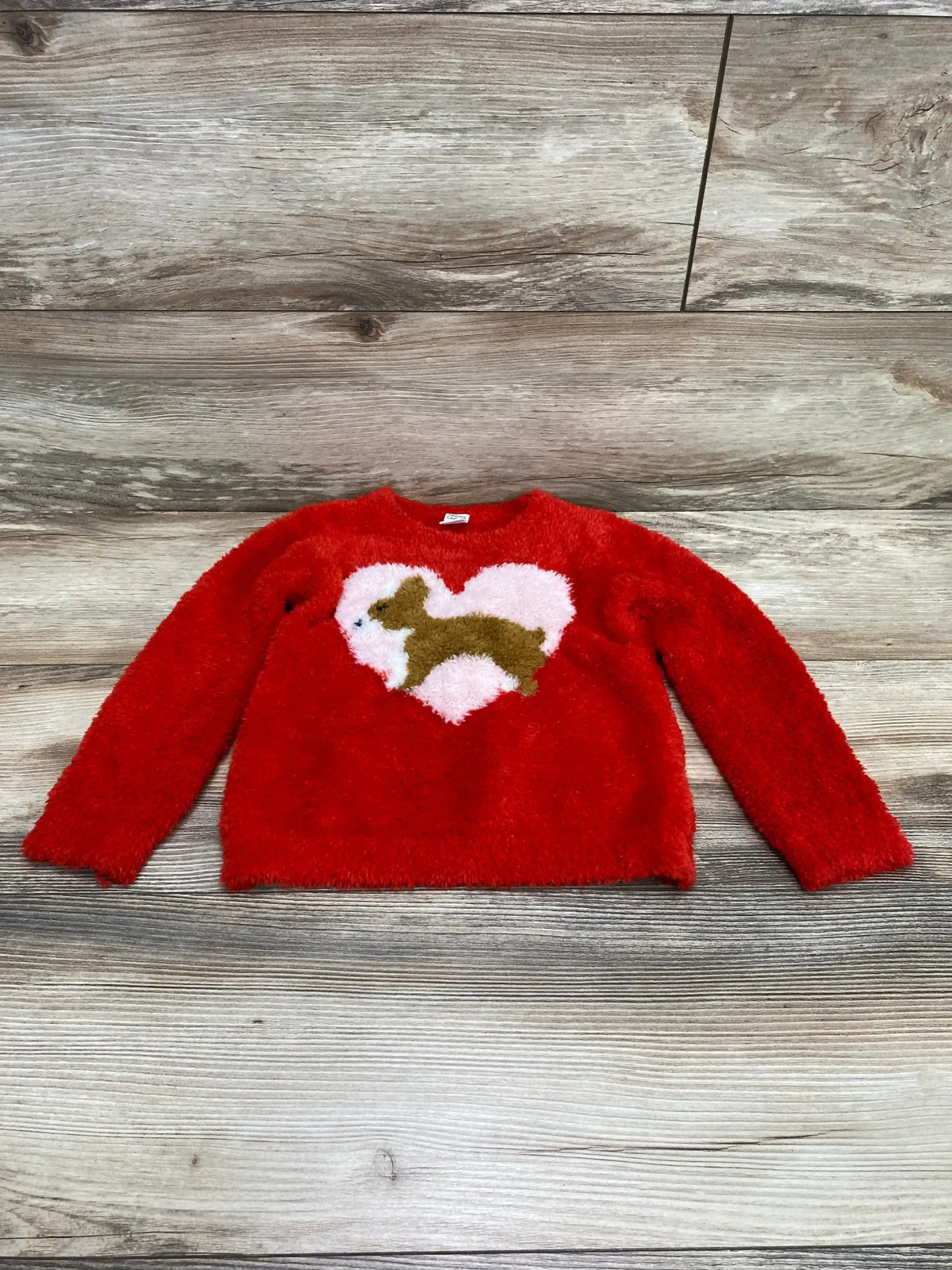 Flat lay of Harper Canyon fluffy intarsia sweater in red, size 24M, with pink heart and brown dog motif on wood background