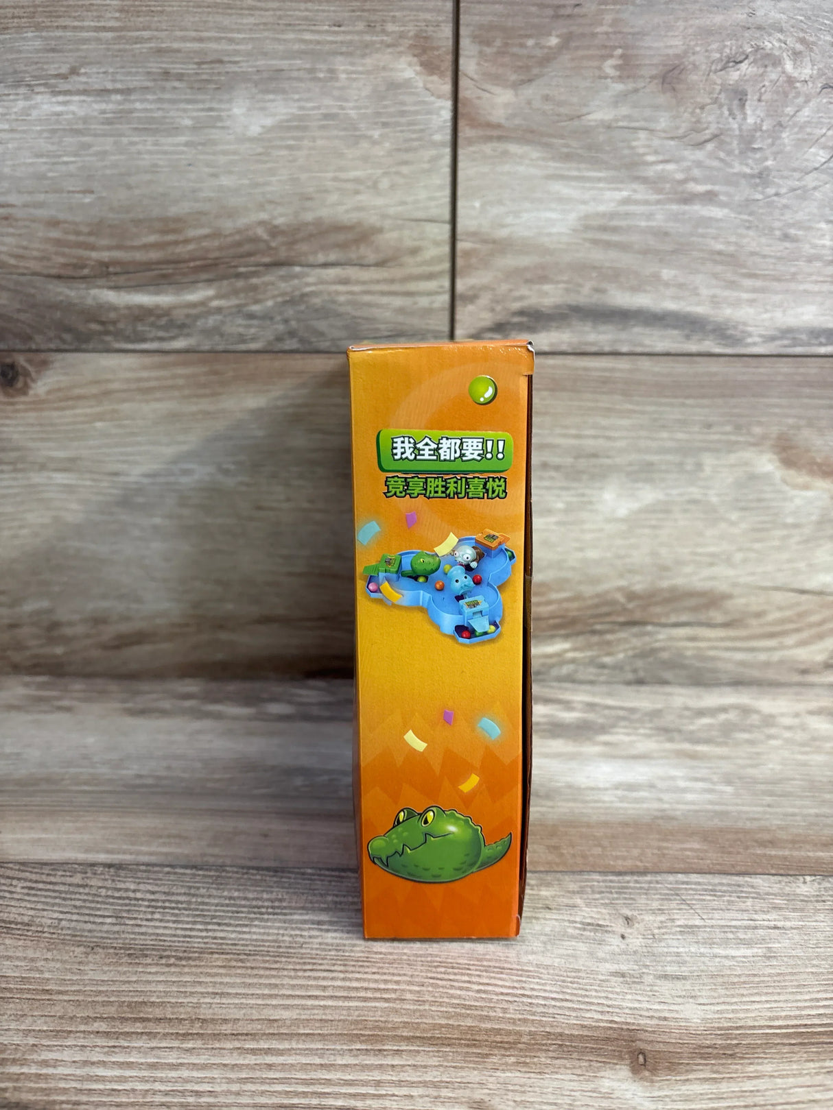 Side view of Plants vs Zombies Press & Play Game Board orange retail box showing zombie graphic and gameplay illustration on wood plank floor