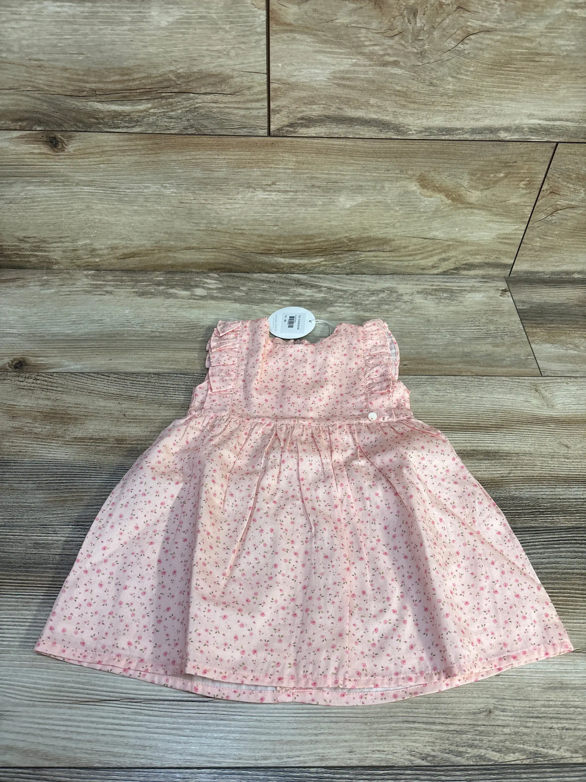 Front view of Wedoble pink floral sleeveless dress showcasing its gathered skirt on a wood-look background