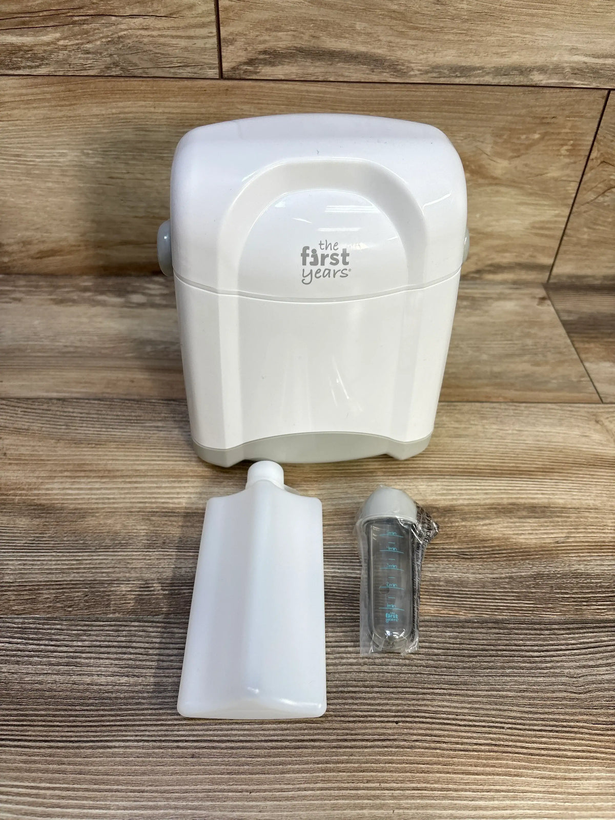 Front view of The First Years Bottle Cooler with a white case, removable ice pack, and baby bottle