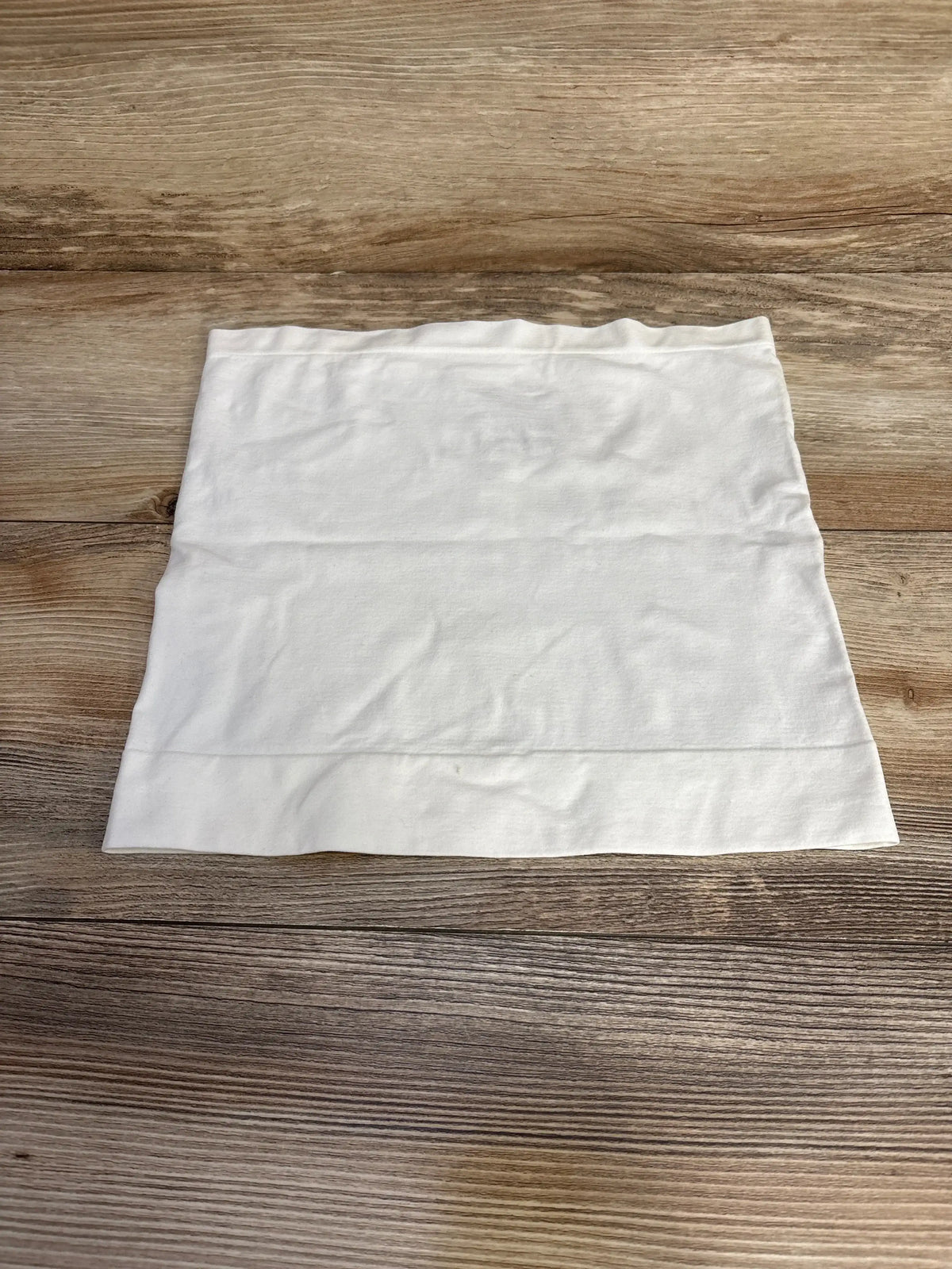 Flat lay of Ingrid and Isabel white BeBand size Small to Medium showing stretchy tube band with top hem on wood background