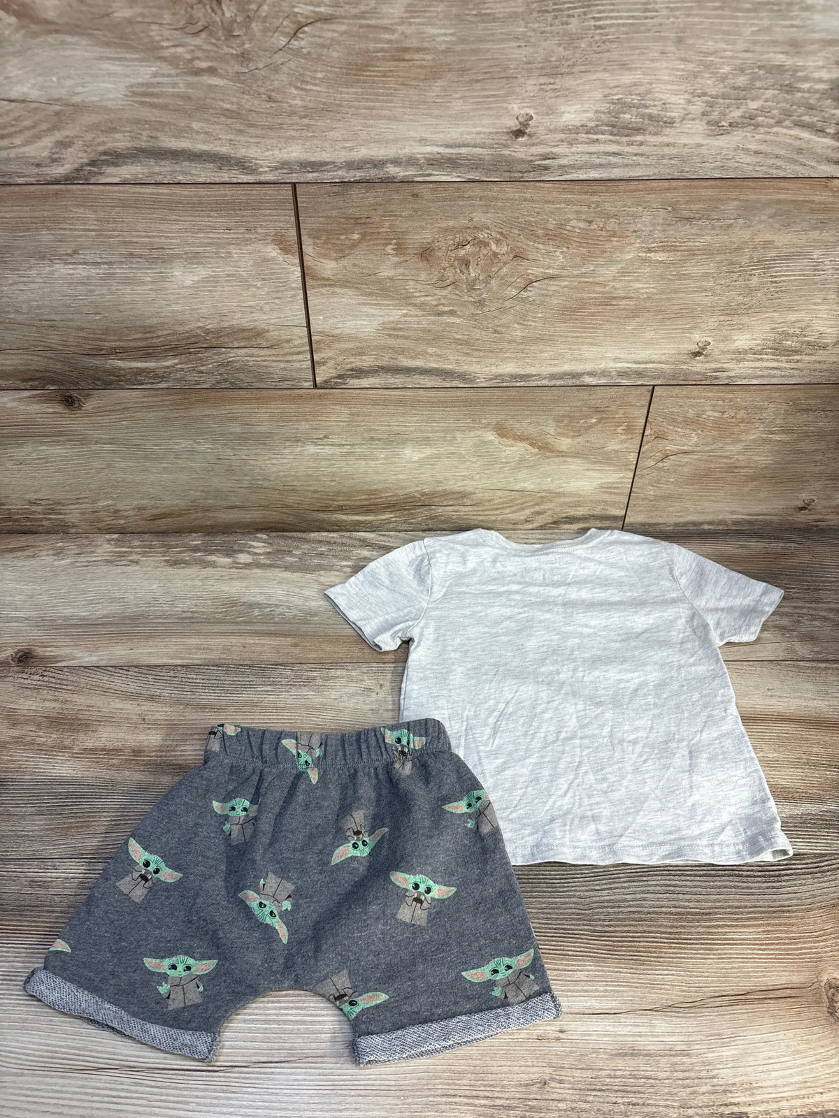Top view of Star Wars Yoda two-piece set showcasing grey shirt and Yoda-print shorts with wood flooring