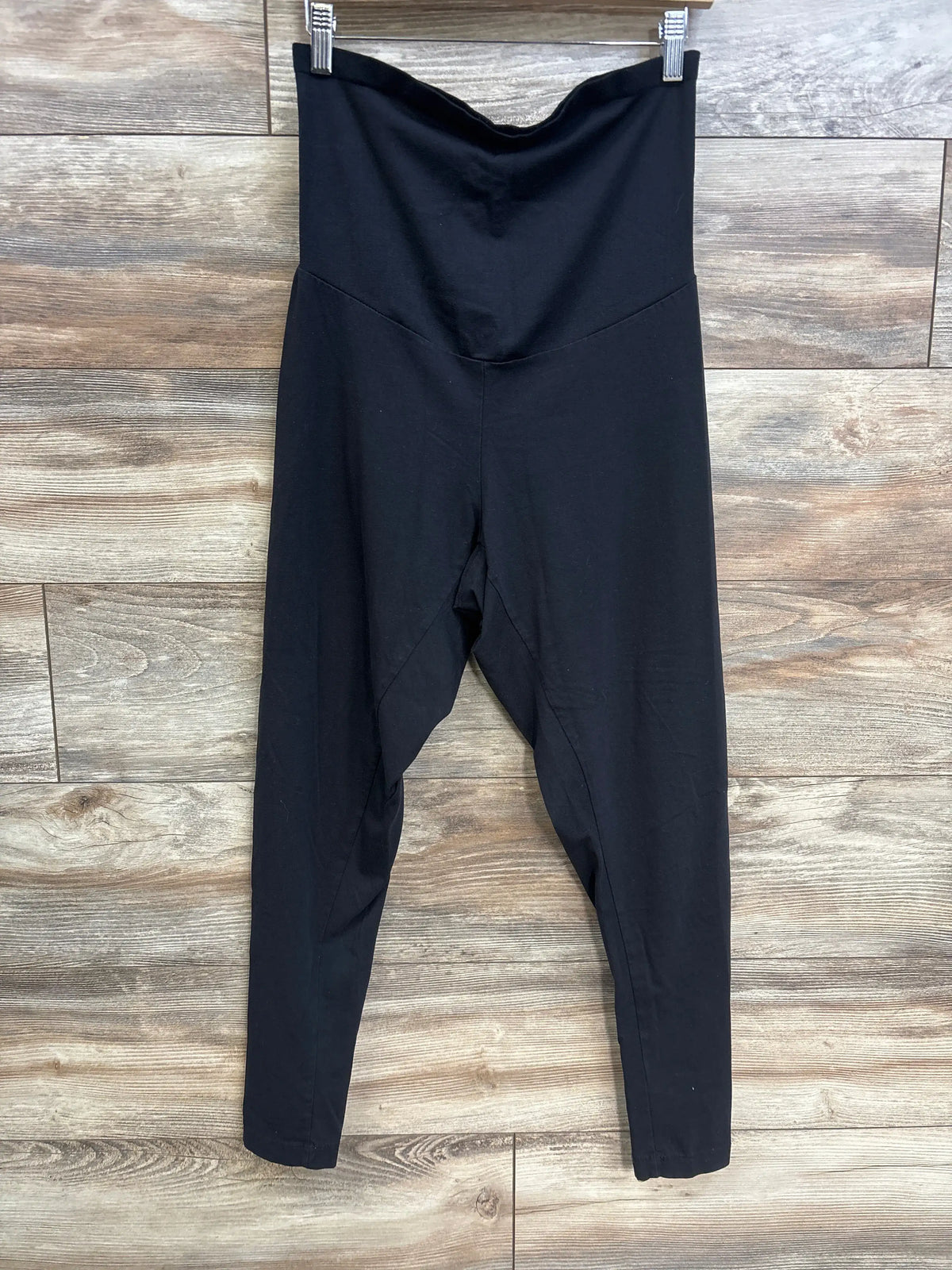 Motherhood Maternity full panel black leggings in size XL on a wood background