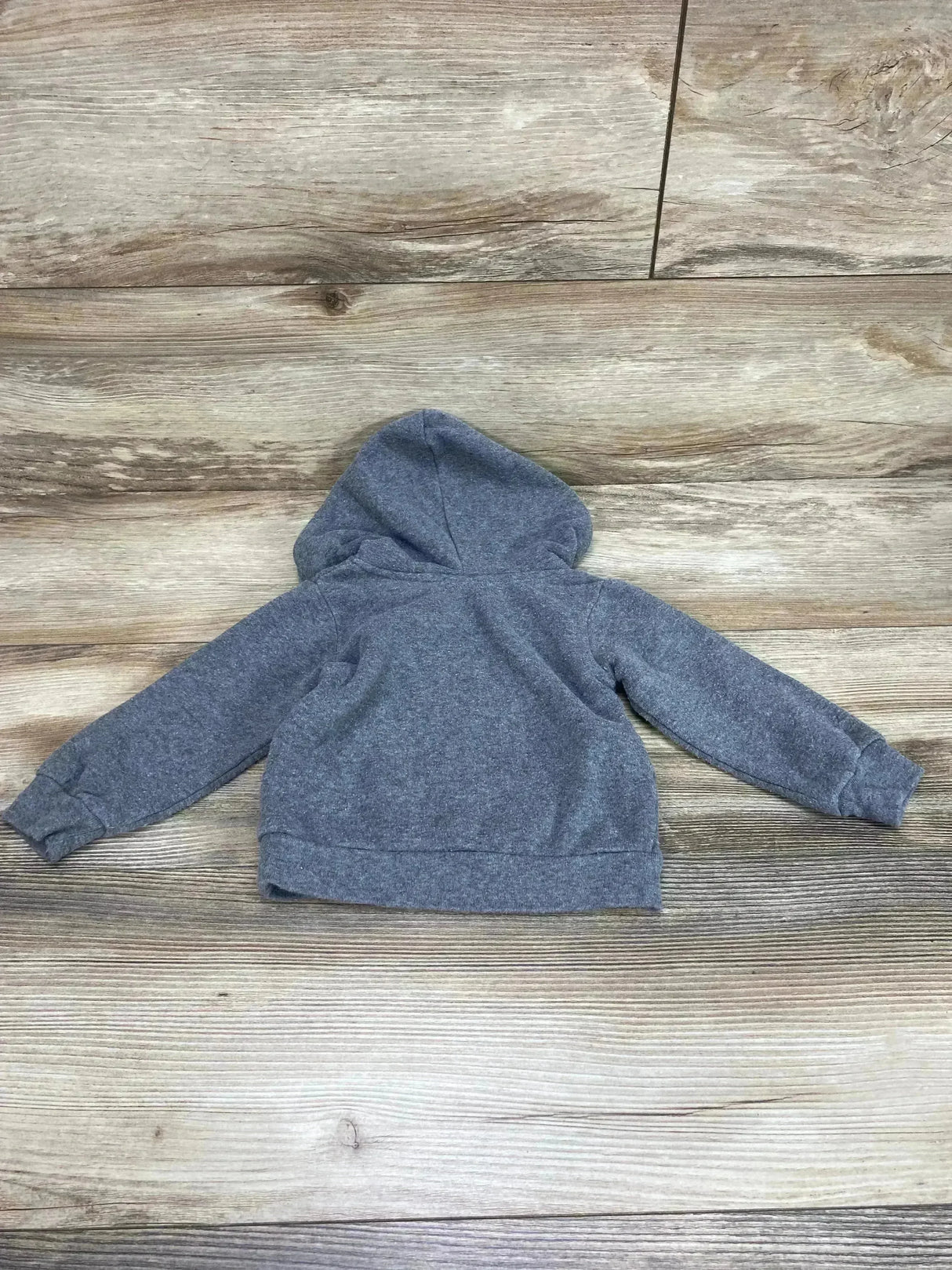 Back view of grey Baby Shark hoodie (12 months) showing attached hood, long sleeves and ribbed hem on wood background