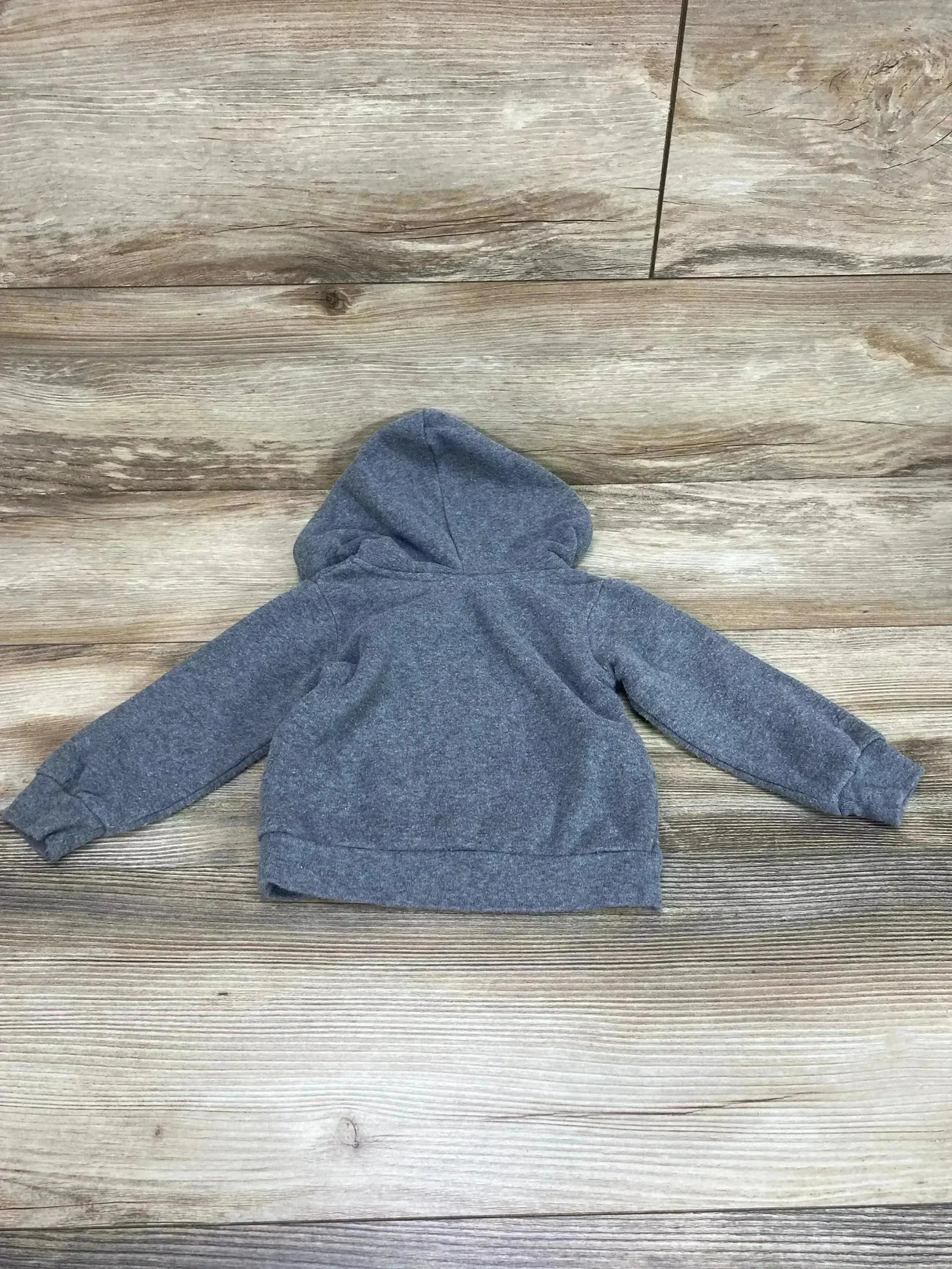 Back view of grey Baby Shark hoodie (12 months) showing attached hood, long sleeves and ribbed hem on wood background