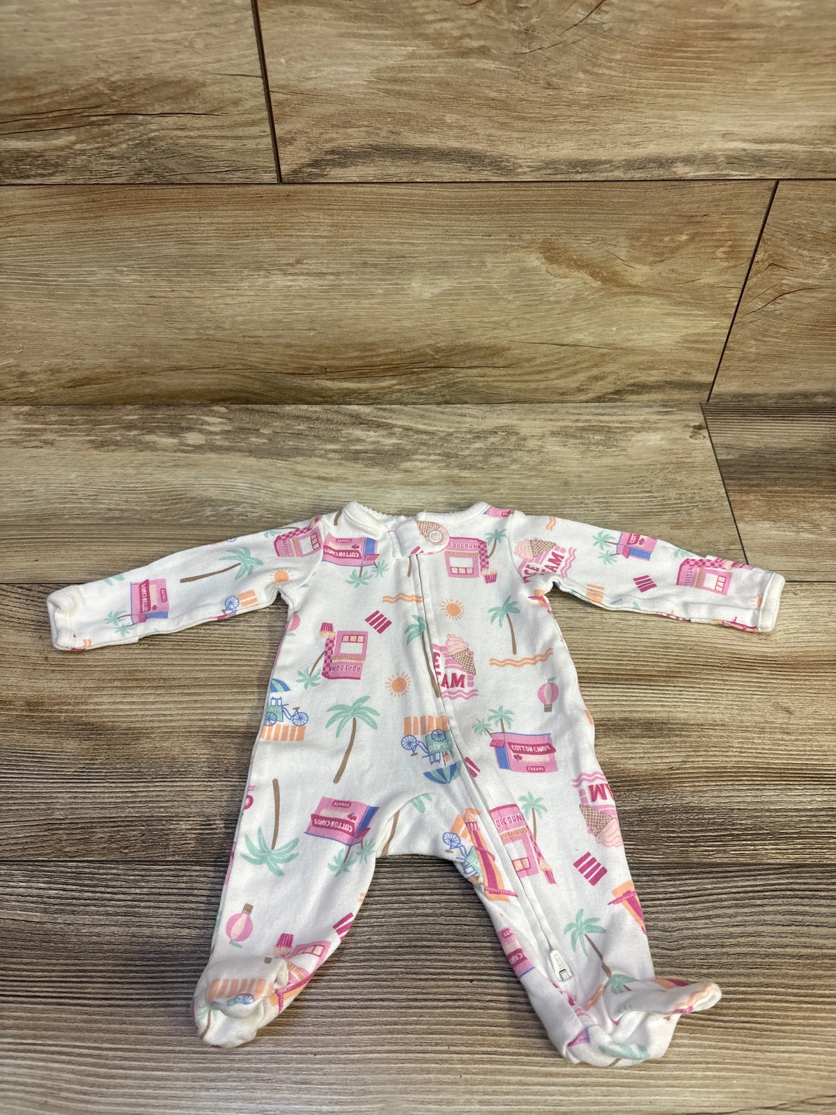 Top view of Child Of Mine white preemie sleeper showcasing long sleeves, footed legs, front zipper, and colorful print