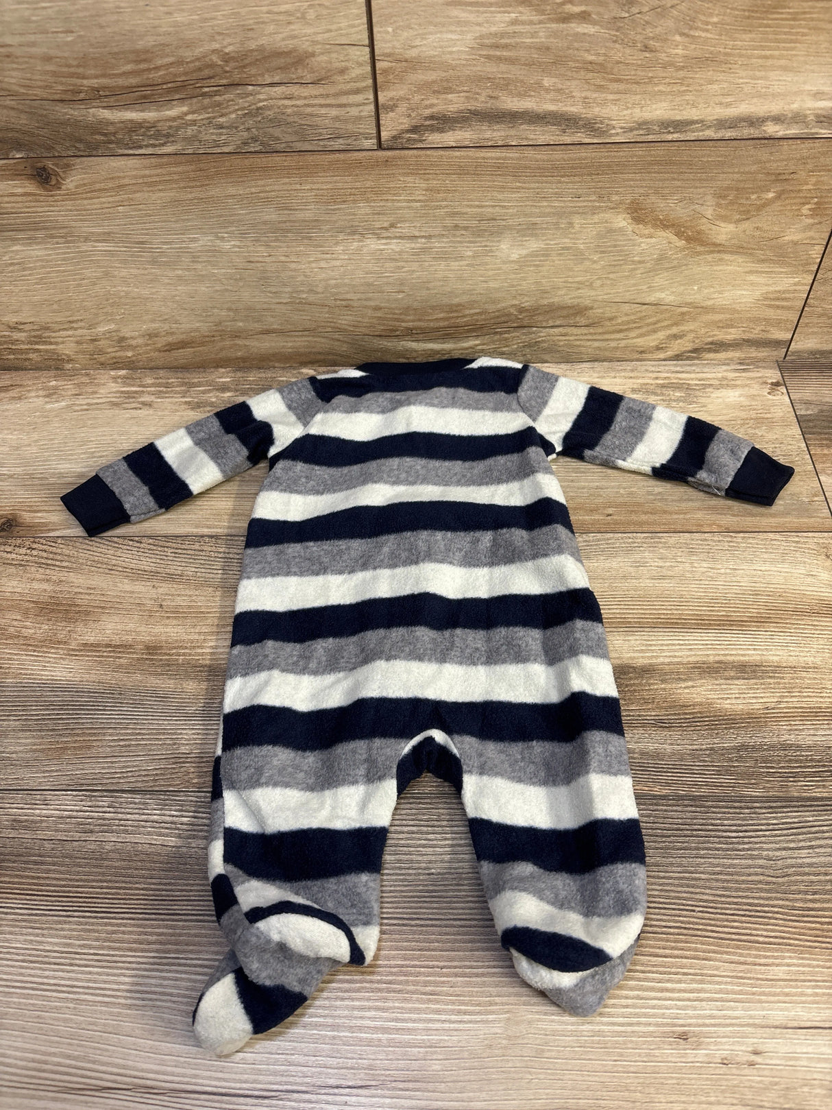Back view of Koala Baby blanket sleeper showcasing navy, gray, and white wide stripes and built-in feet on wood plank background