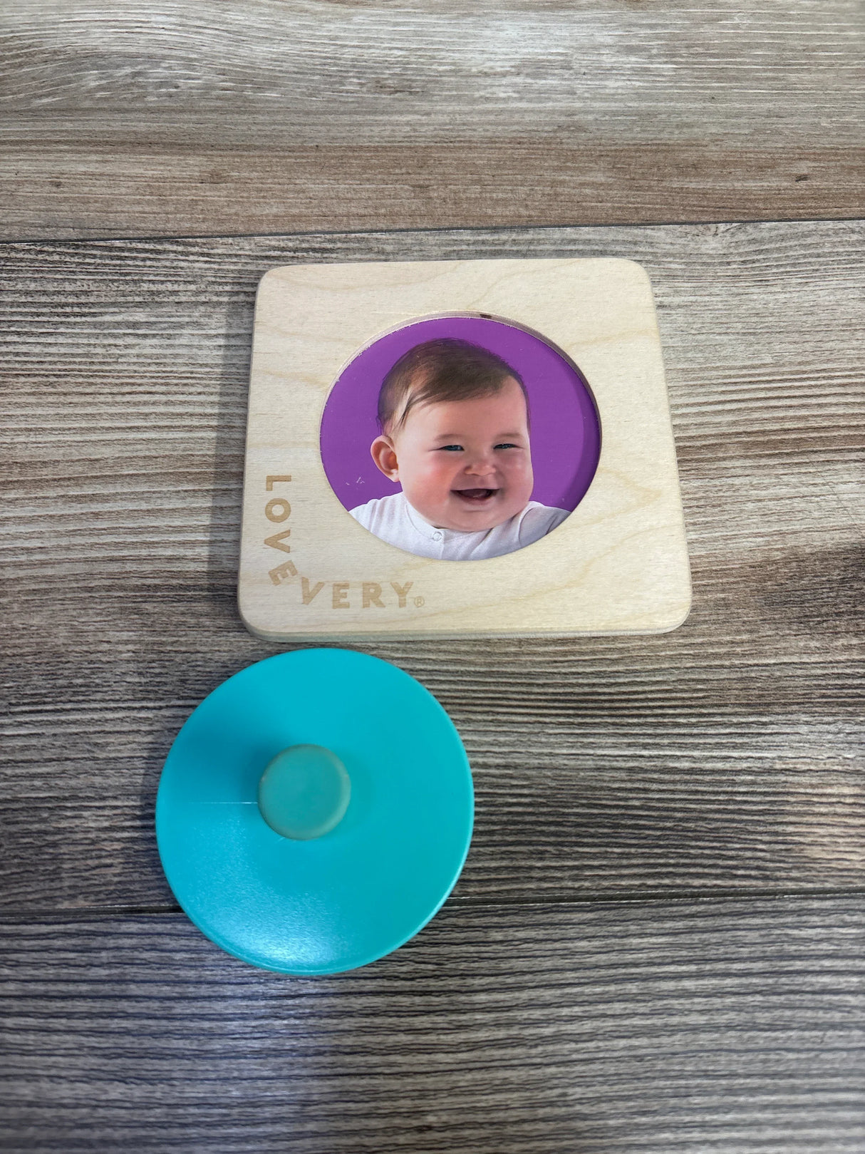 Lovevery wooden baby puzzle with round blue knob on wood table
