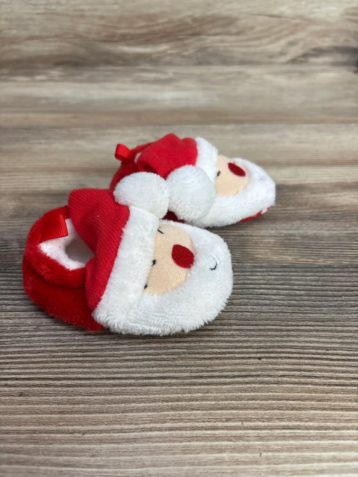 Adorable Santa baby booties with red hat and white beard, perfect for holiday photos and newborns.
