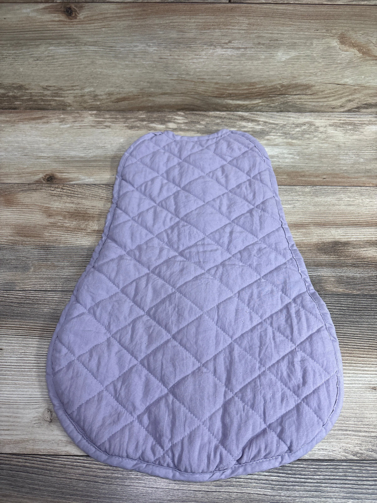 Purple quilted wearable blanket swaddle for infants by Me n Mommy To Be on a wooden background