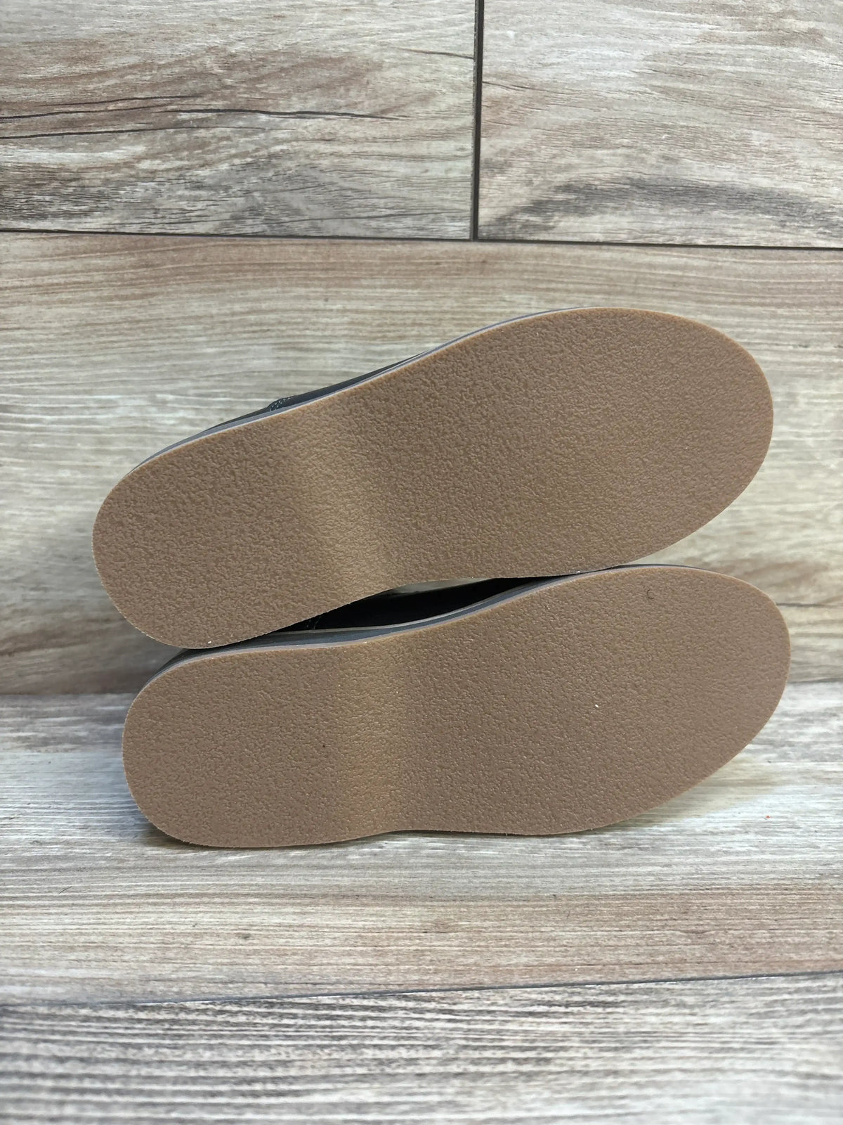 Side view of Cat and Jack Neal black toddler loafers size 11C showing slip-on upper and clean tan rubber soles on wood background