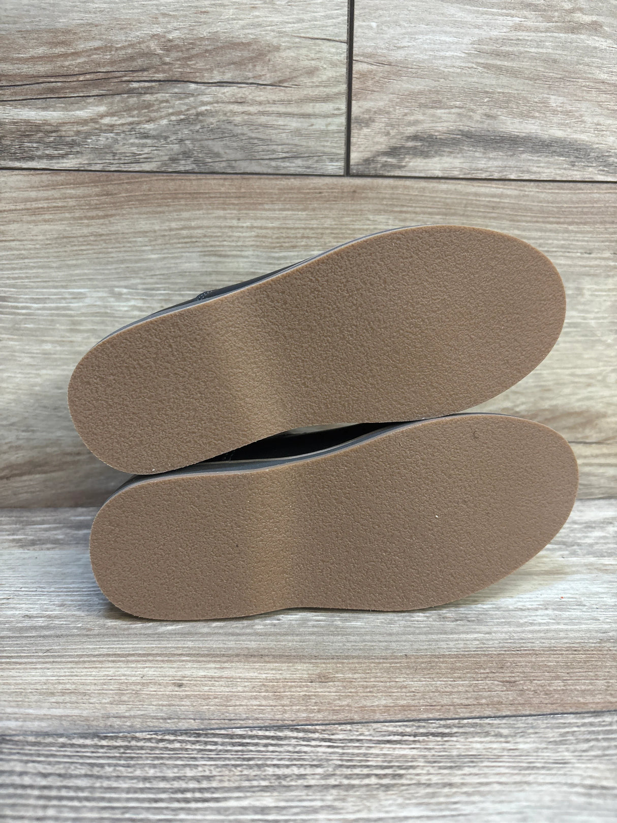 Bottom view of NWoT Cat & Jack Neal black toddler loafers, size 11C, showing clean tan rubber soles on light wood background