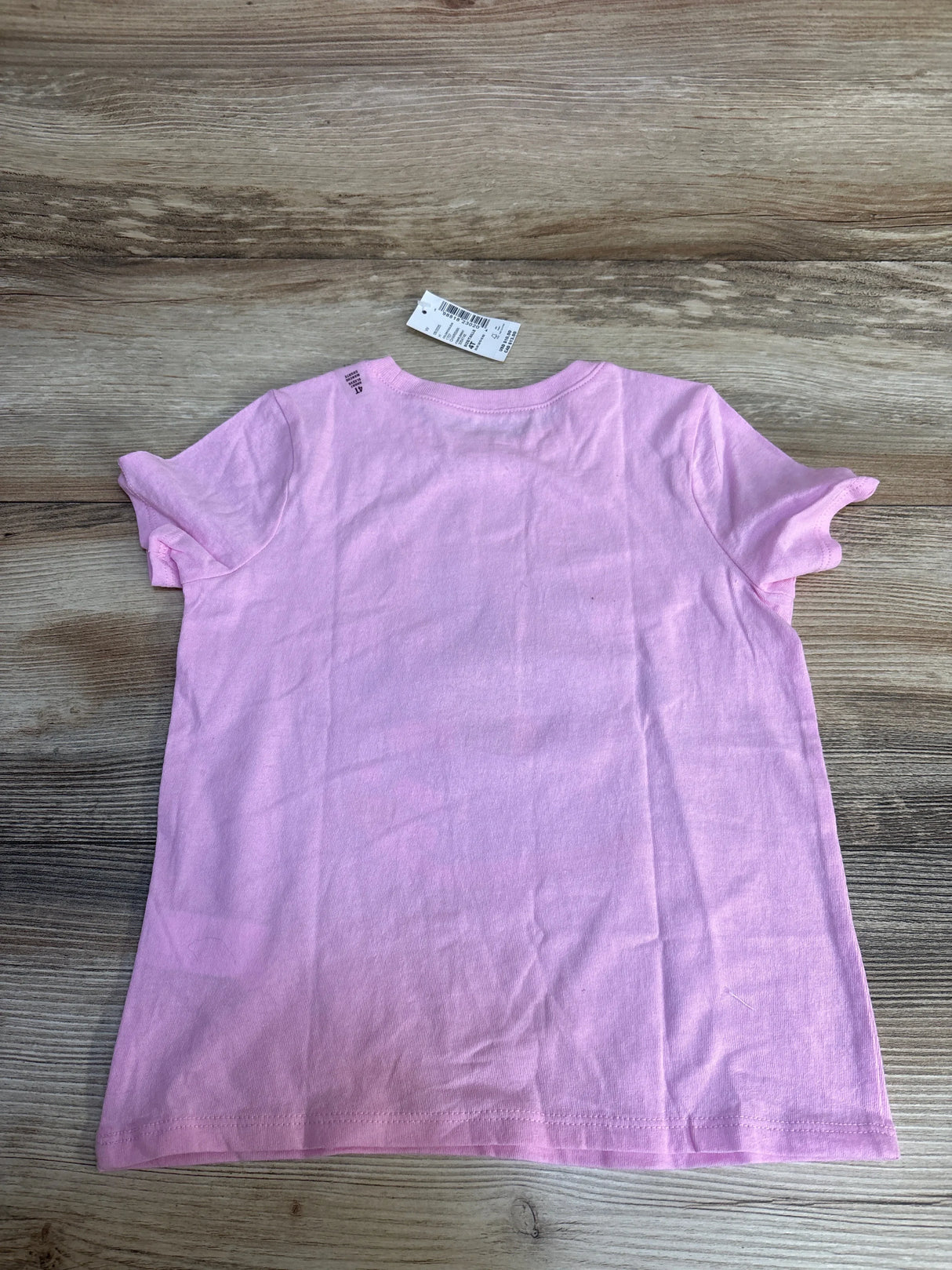 Pink kids short sleeve t-shirt size 4T on wood floor, resale clothing for children