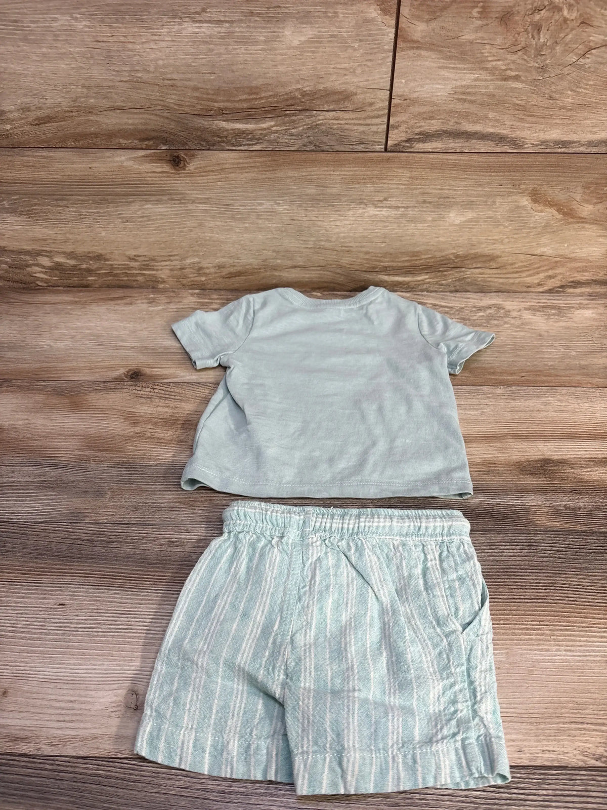 Flat-lay of C&C California mint green short-sleeve shirt and striped linen shorts, 12 months, elastic waist on wood background