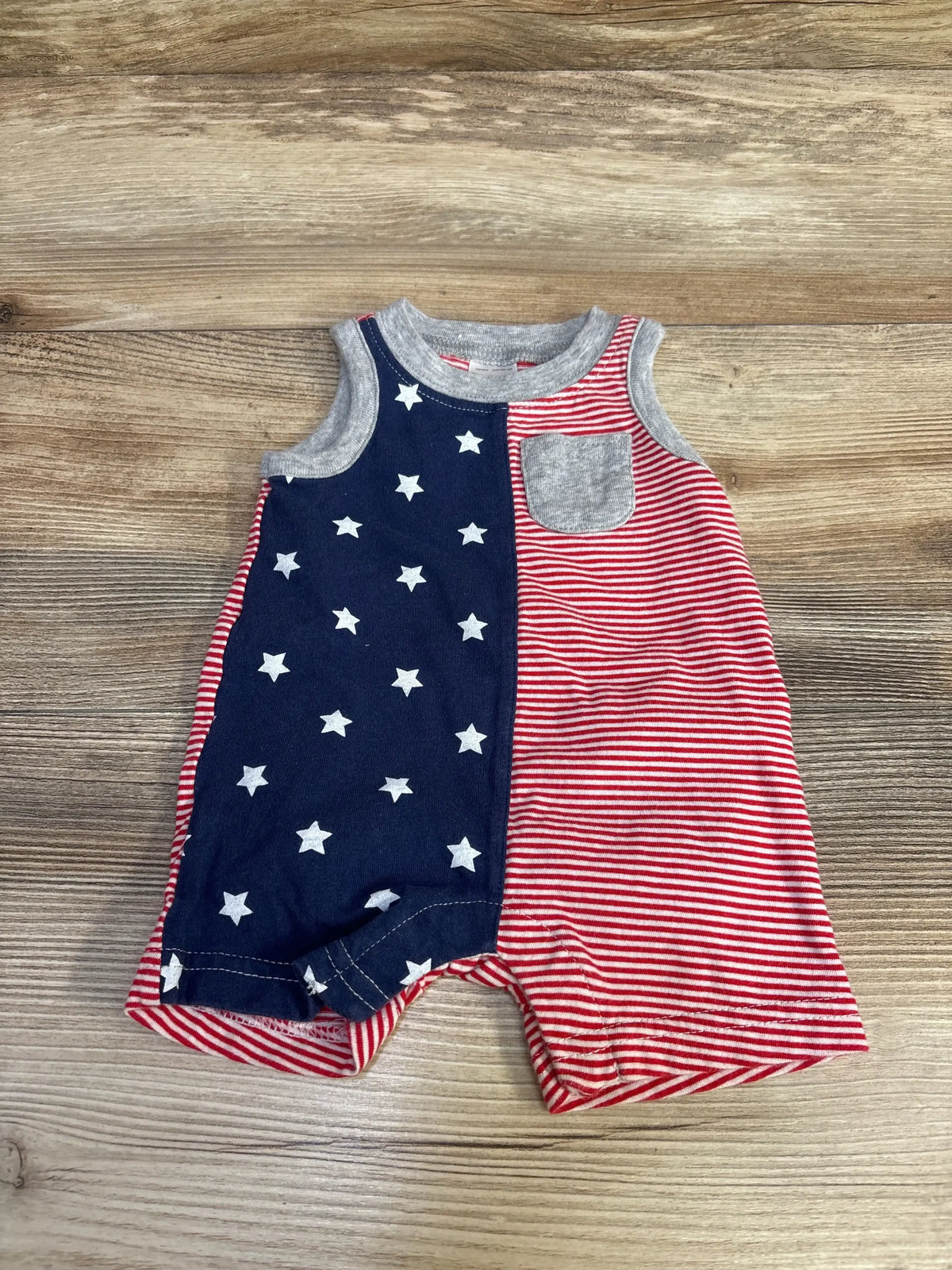 Front view of Carter’s newborn red tank romper with large American flag print, sleeveless with snap crotch on white background